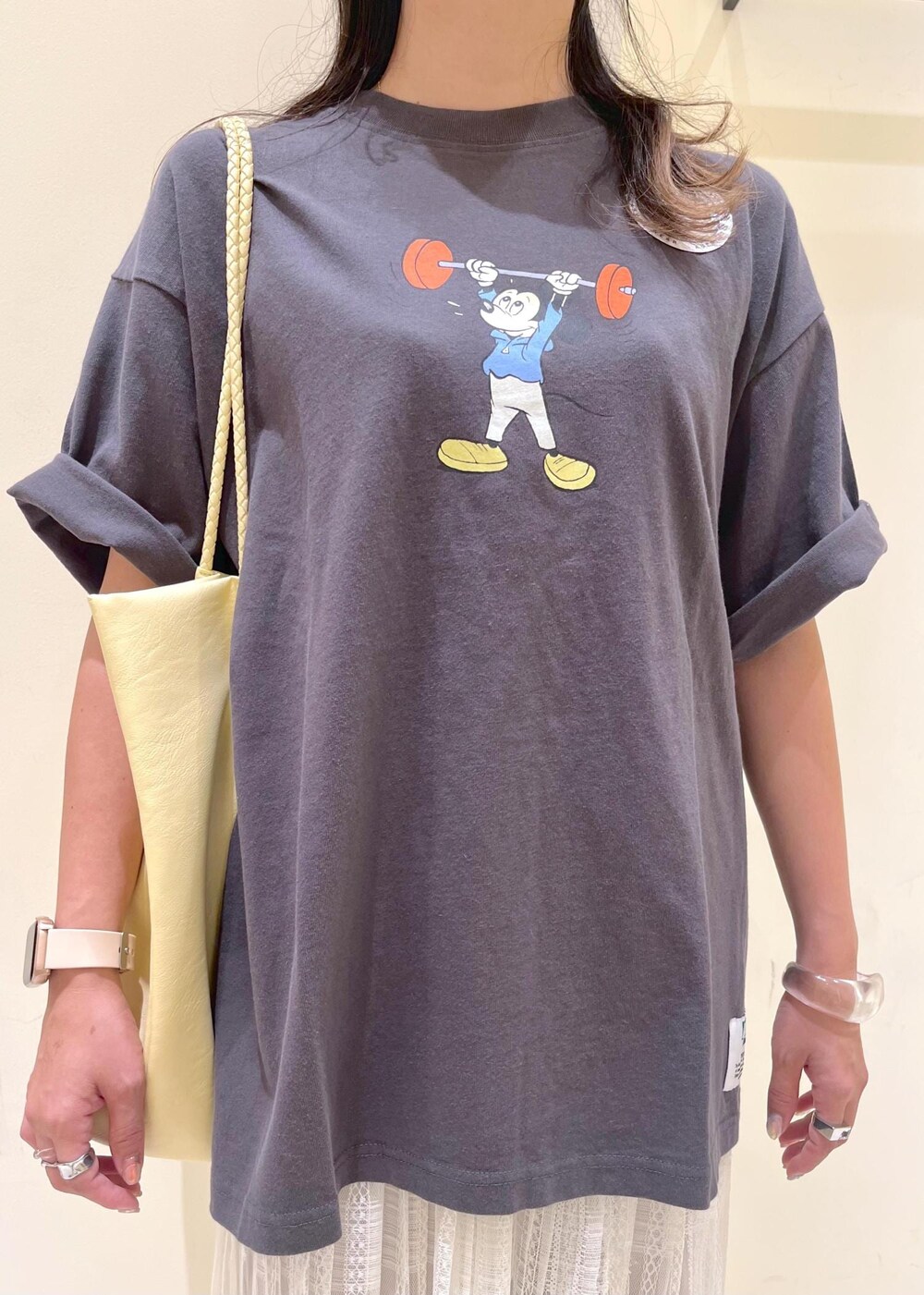 イエロー系のトートバッグ、ホワイト系のスカート、ベージュ系のその他パンツを着用したレディースの夏コーディネートの6枚目の写真