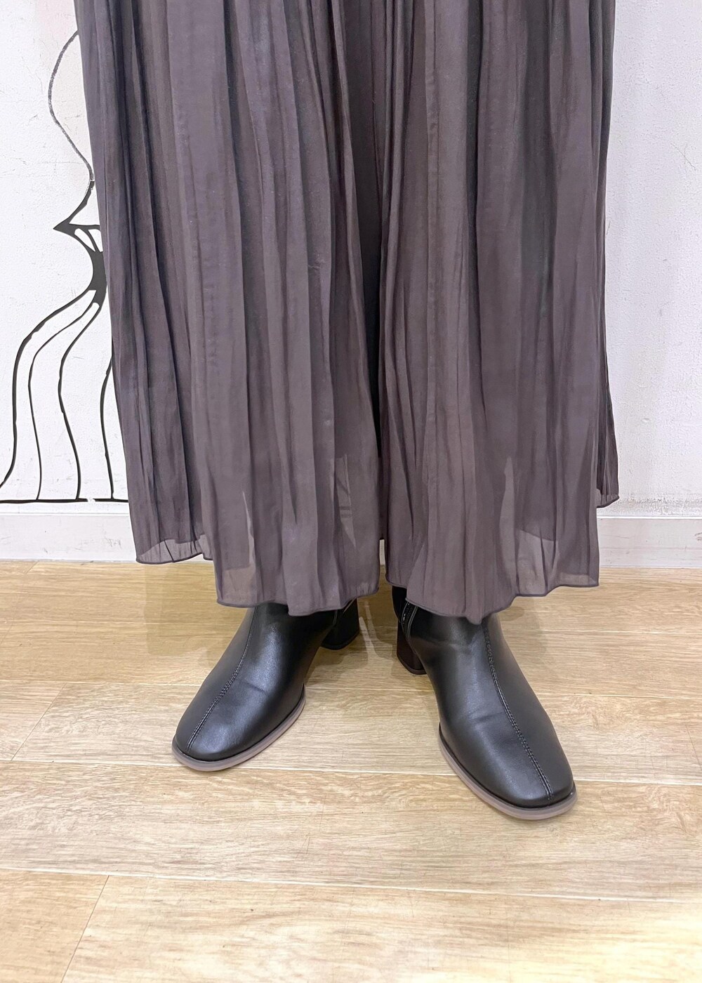 ブラック系のブーツ、ブルー系のニット/セーター、ブラウン系のスカートを着用したレディースの秋コーディネートの10枚目の写真