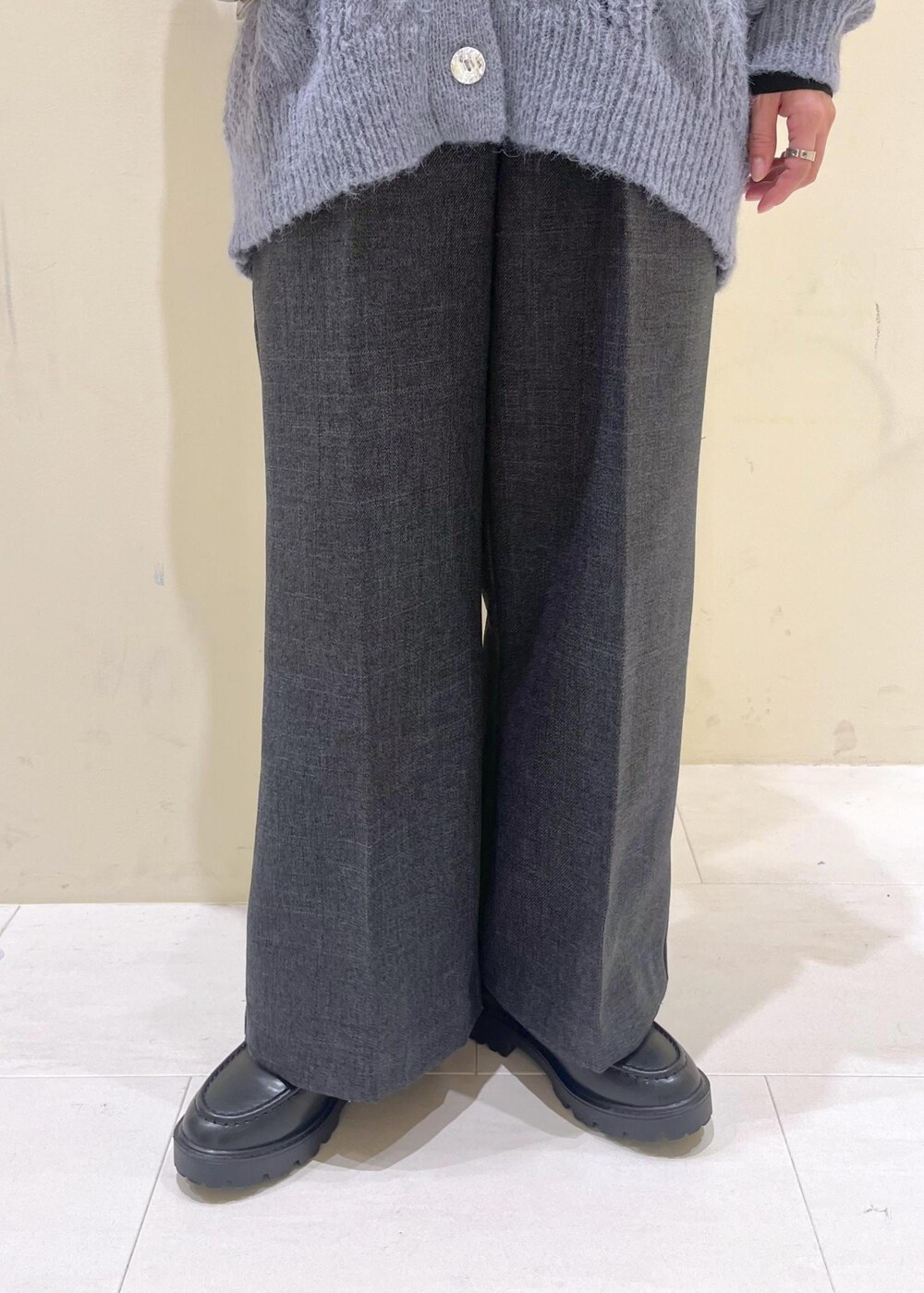 ブラック系のショルダーバッグ、ブラック系のニット/セーター、グレー系のスラックスを着用したレディースの秋コーディネートの9枚目の写真