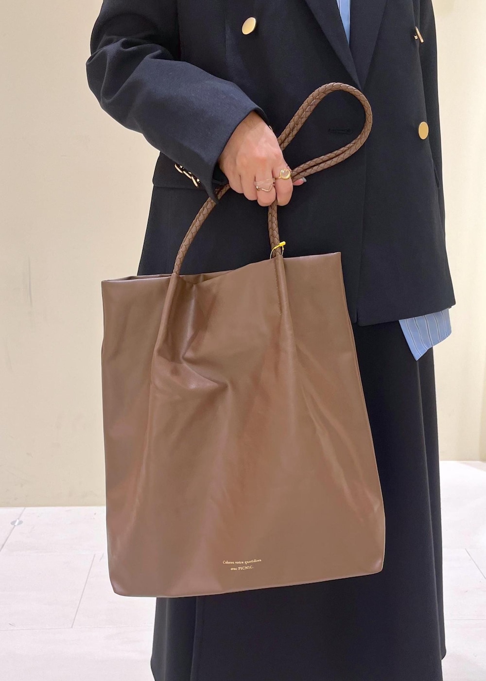 ブラウン系のトートバッグ、ブラウン系のトートバッグ、ブルー系のテーラードジャケットを着用したレディースの秋コーディネートの8枚目の写真