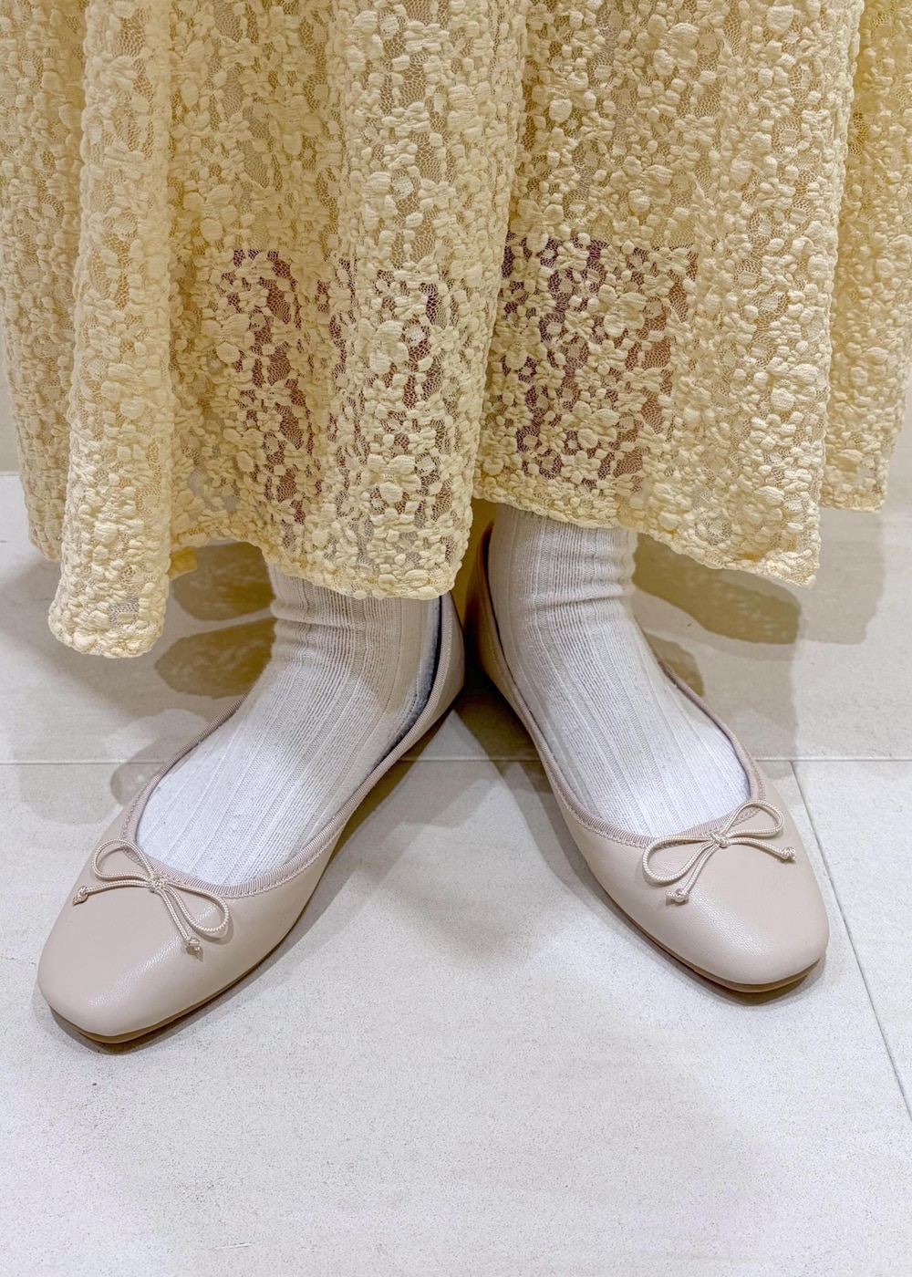 ホワイト系のバレエシューズ、ホワイト系のニット/セーター、ホワイト系のボストンバッグを着用したレディースの冬コーディネートの10枚目の写真