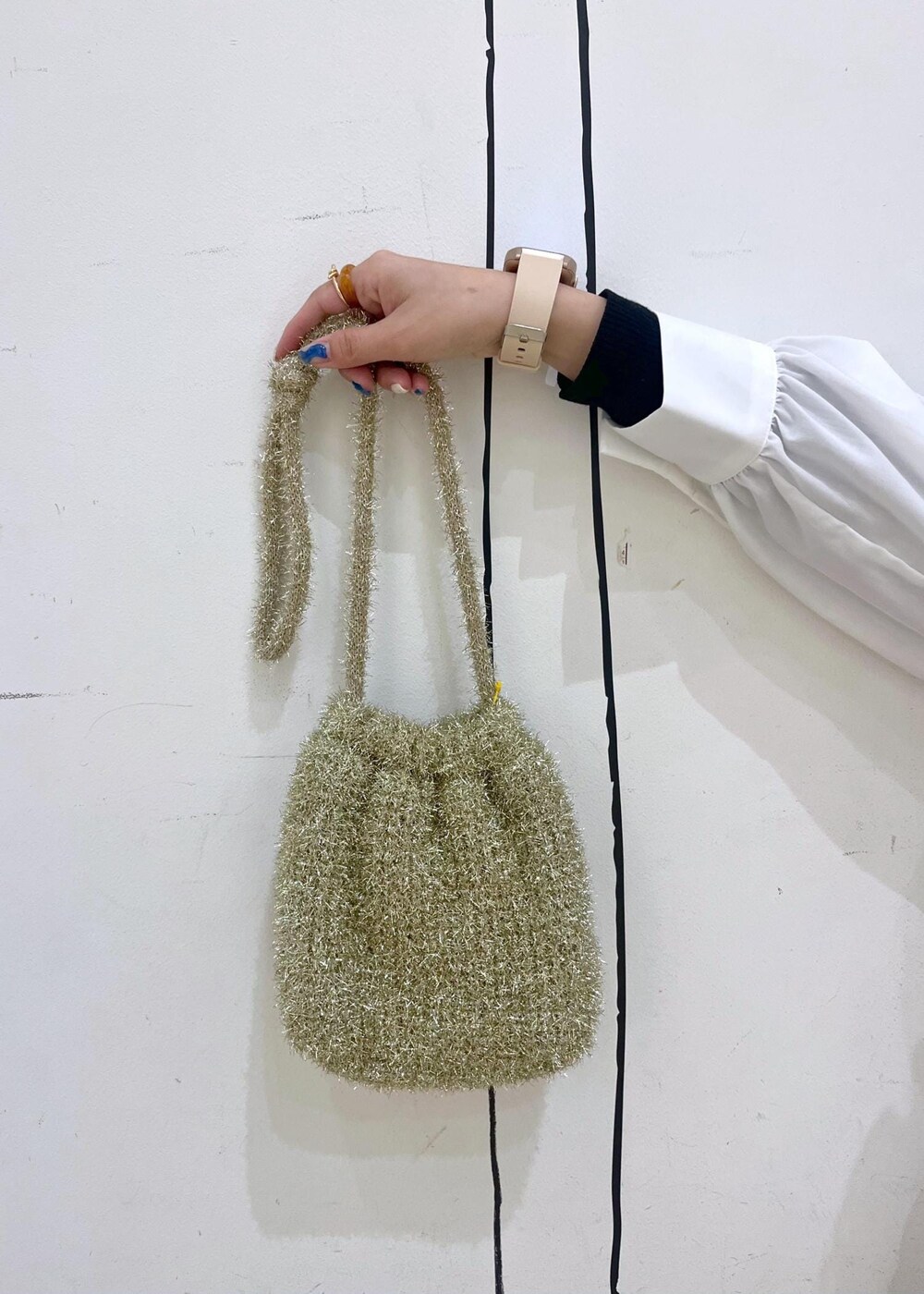 ブラック系のニット/セーター、ゴールド系のバレエシューズ、ホワイト系のキャミソールを着用したレディースの冬コーディネートの9枚目の写真