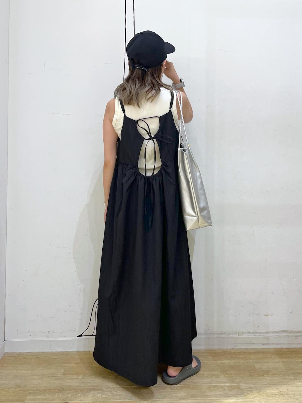 シルバー系のトートバッグ、ベージュ系のタンクトップ、ブラック系のワンピースを着用したレディースの夏コーディネートの4枚目の写真