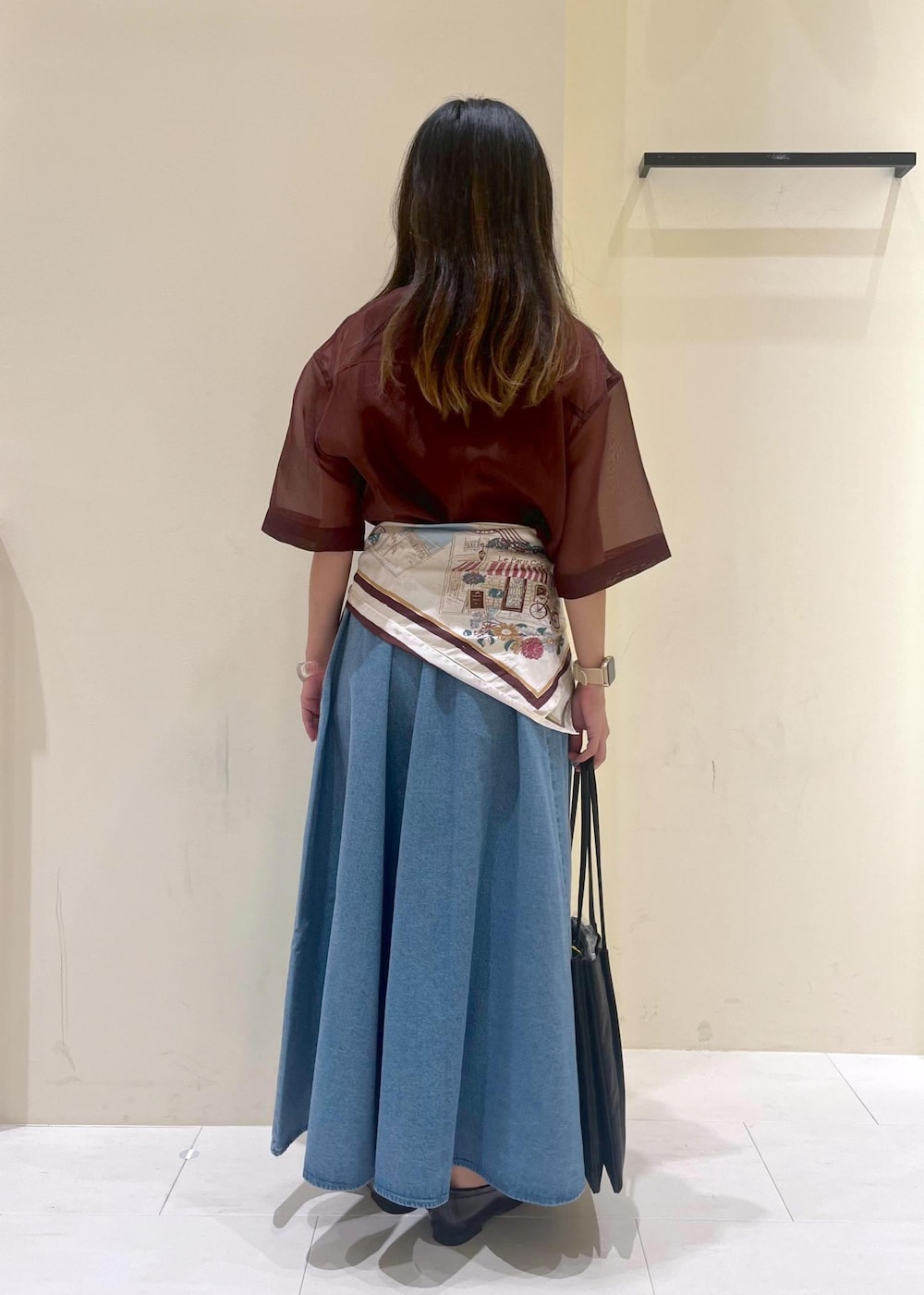 ブラック系のトートバッグ、ブラウン系のシャツ/ブラウス、ブルー系のスカートを着用したレディースの秋コーディネートの4枚目の写真