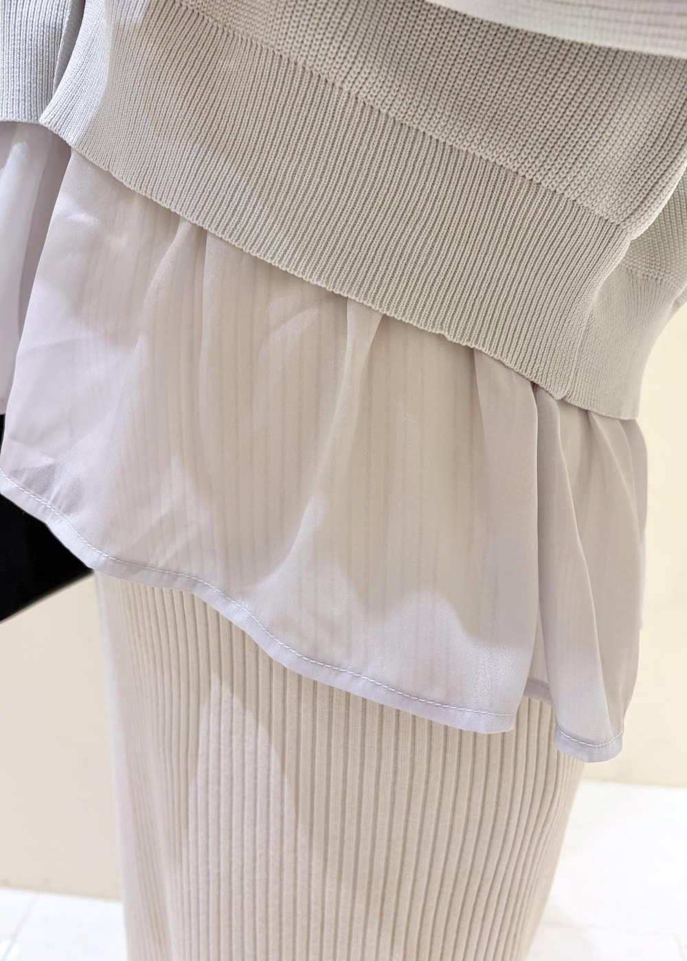 ブラック系のショルダーバッグ、ブラック系のパンプス、ホワイト系のスカートを着用したレディースの春コーディネートの6枚目の写真