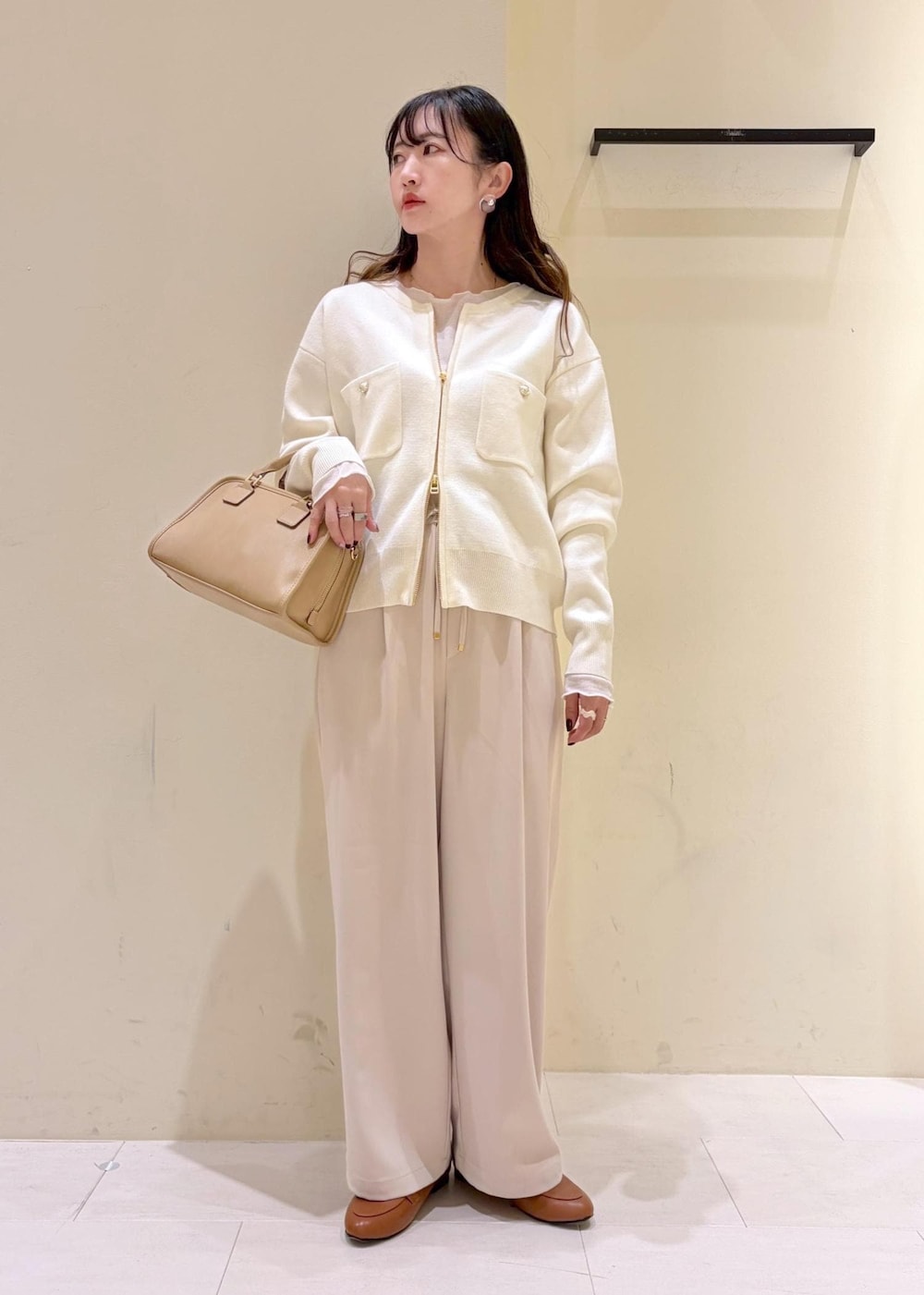 ホワイト系のTシャツ/カットソー、イエロー系のローファー、ベージュ系のボストンバッグを着用したレディースの冬コーディネートの2枚目の写真