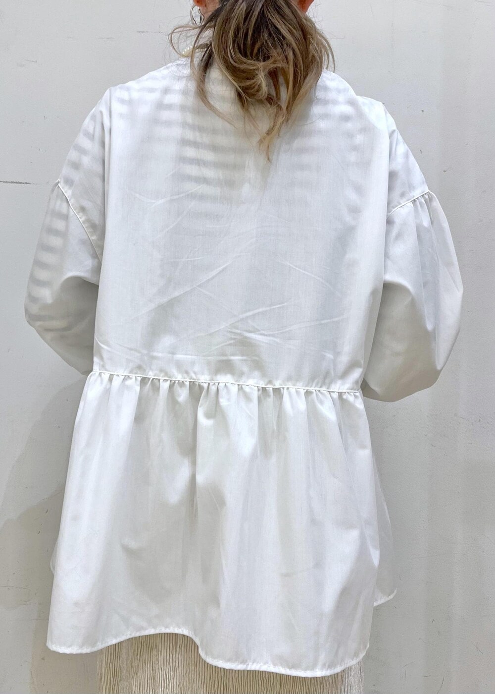 ベージュ系のハンドバッグ、ホワイト系のニット/セーター、シルバー系のバレエシューズを着用したレディースの冬コーディネートの7枚目の写真