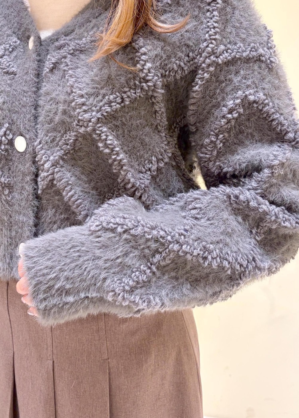 ベージュ系のスカート、グレー系のカーディガン/ボレロ、ホワイト系のTシャツ/カットソーを着用したレディースの冬コーディネートの6枚目の写真