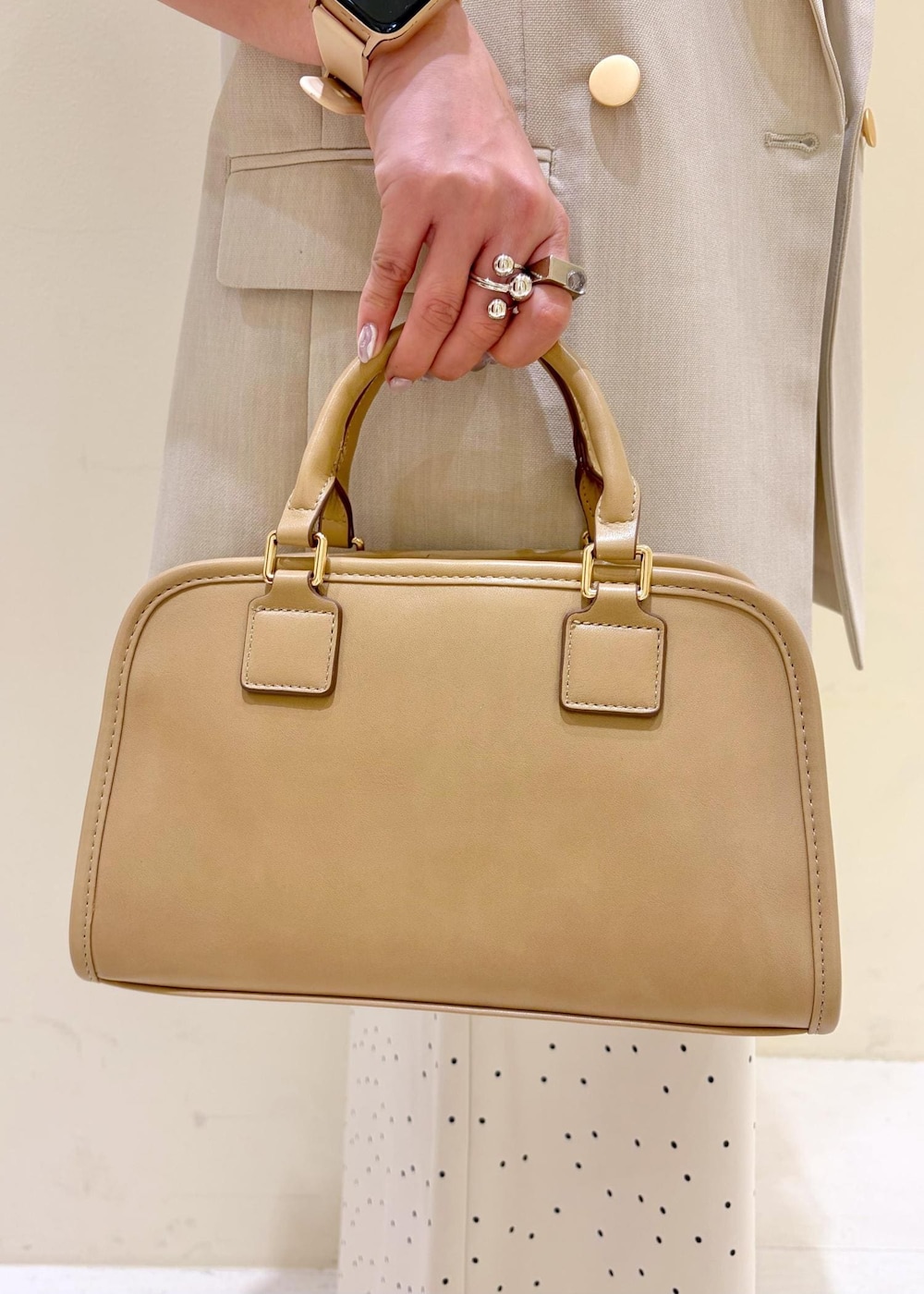 ベージュ系のボストンバッグ、ブルー系のTシャツ/カットソー、ベージュ系のベストを着用したレディースの春コーディネートの9枚目の写真