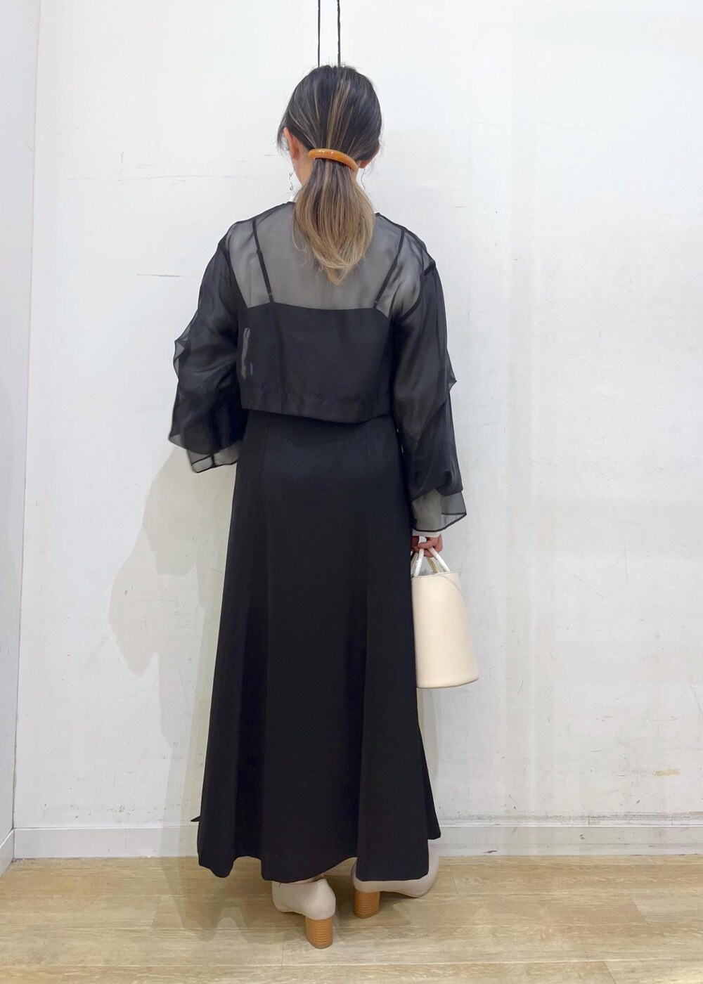 ベージュ系のローファー、ホワイト系のショルダーバッグ、ブラック系のドレスを着用したレディースの冬コーディネートの4枚目の写真