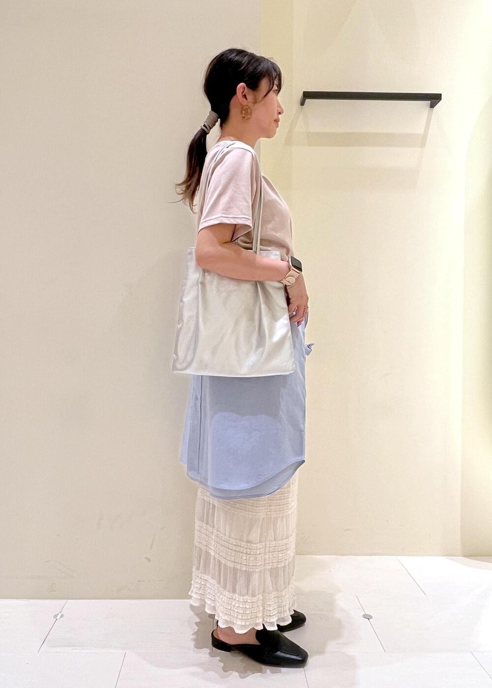 シルバー系のトートバッグ、ブラック系のローファー、ベージュ系のTシャツ/カットソーを着用したレディースの春コーディネートの3枚目の写真