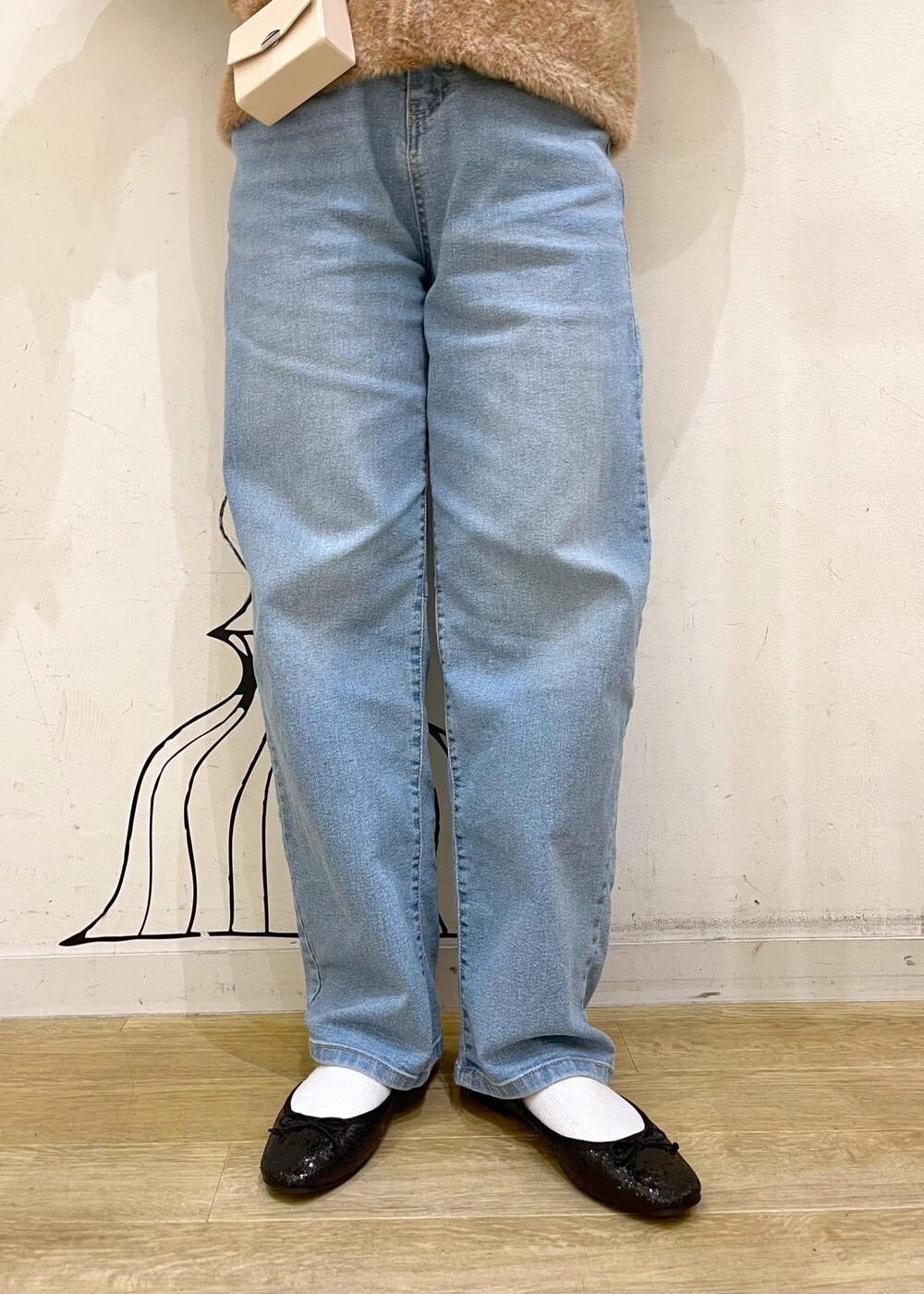 ブルー系のデニムパンツ、イエロー系のカーディガン/ボレロ、ホワイト系のショルダーバッグを着用したレディースの秋コーディネートの8枚目の写真