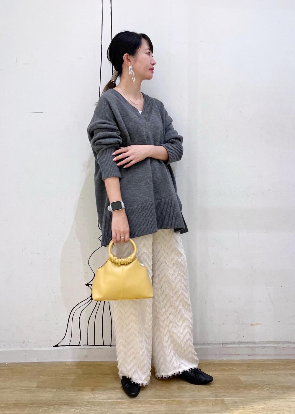 グレー系のタンクトップ、ブラック系のパンプス、イエロー系のショルダーバッグを着用したレディースの夏コーディネートの3枚目の写真