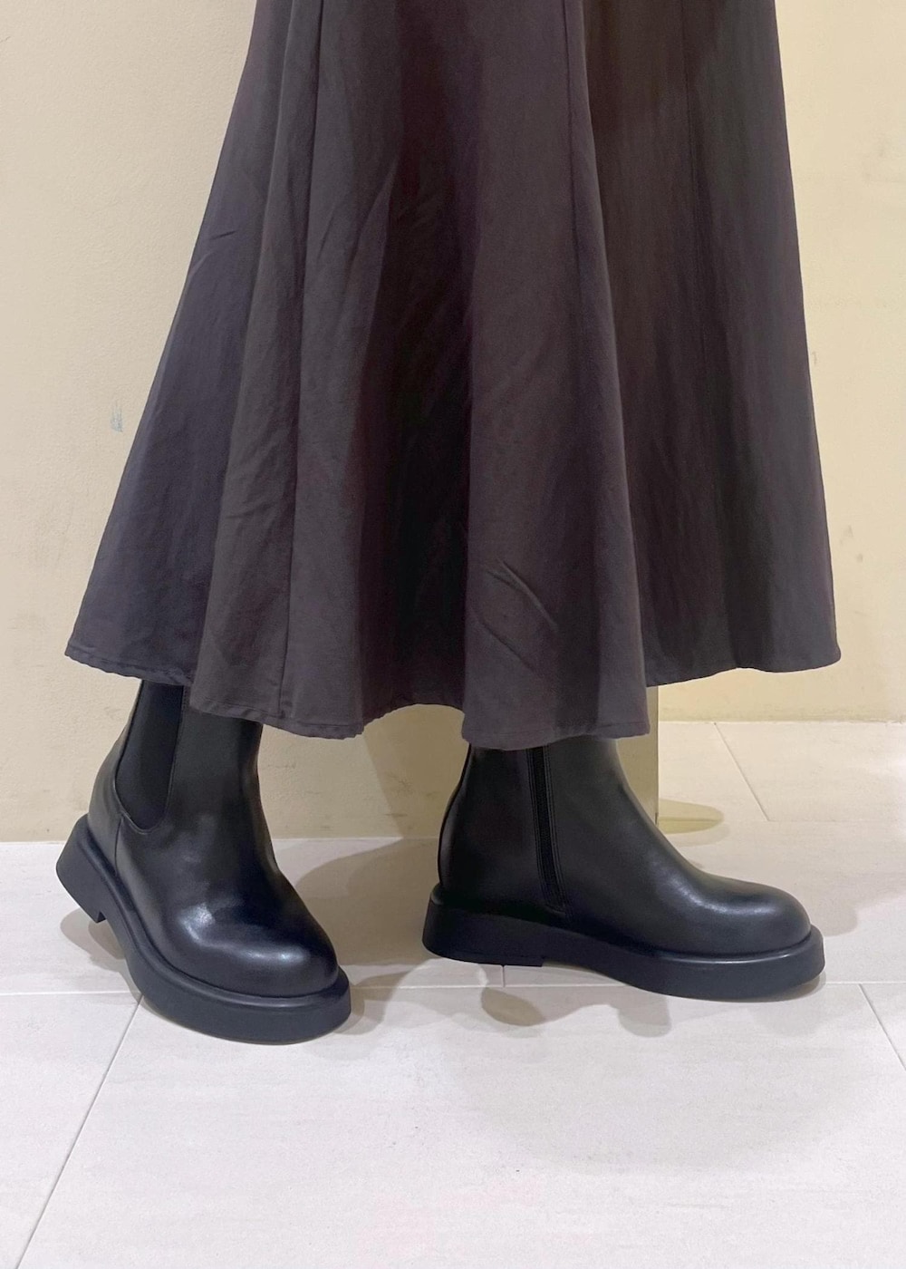 ホワイト系のニット/セーター、グレー系のスカート、レッド系のショルダーバッグを着用したレディースの冬コーディネートの8枚目の写真