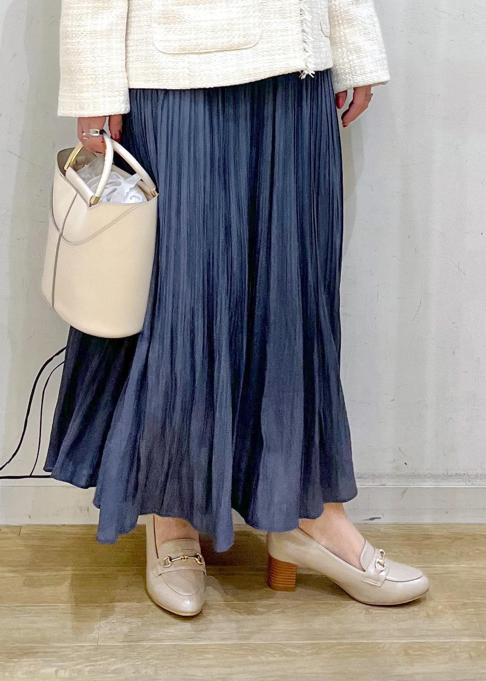 ブルー系のスカート、ベージュ系のローファー、ホワイト系のショルダーバッグを着用したレディースの冬コーディネートの9枚目の写真