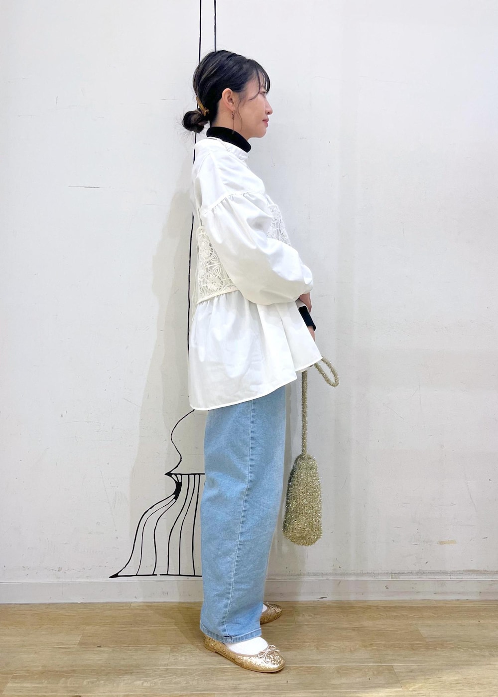 ブラック系のニット/セーター、ゴールド系のバレエシューズ、ホワイト系のキャミソールを着用したレディースの冬コーディネートの4枚目の写真