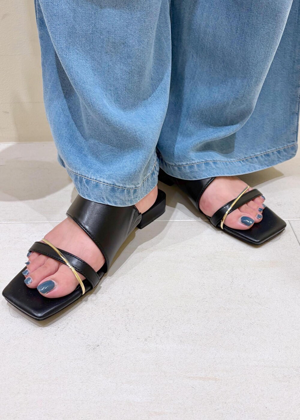 ブラック系のハンドバッグ、ブルー系のデニムパンツ、ブラック系のサンダルを着用したレディースの夏コーディネートの10枚目の写真
