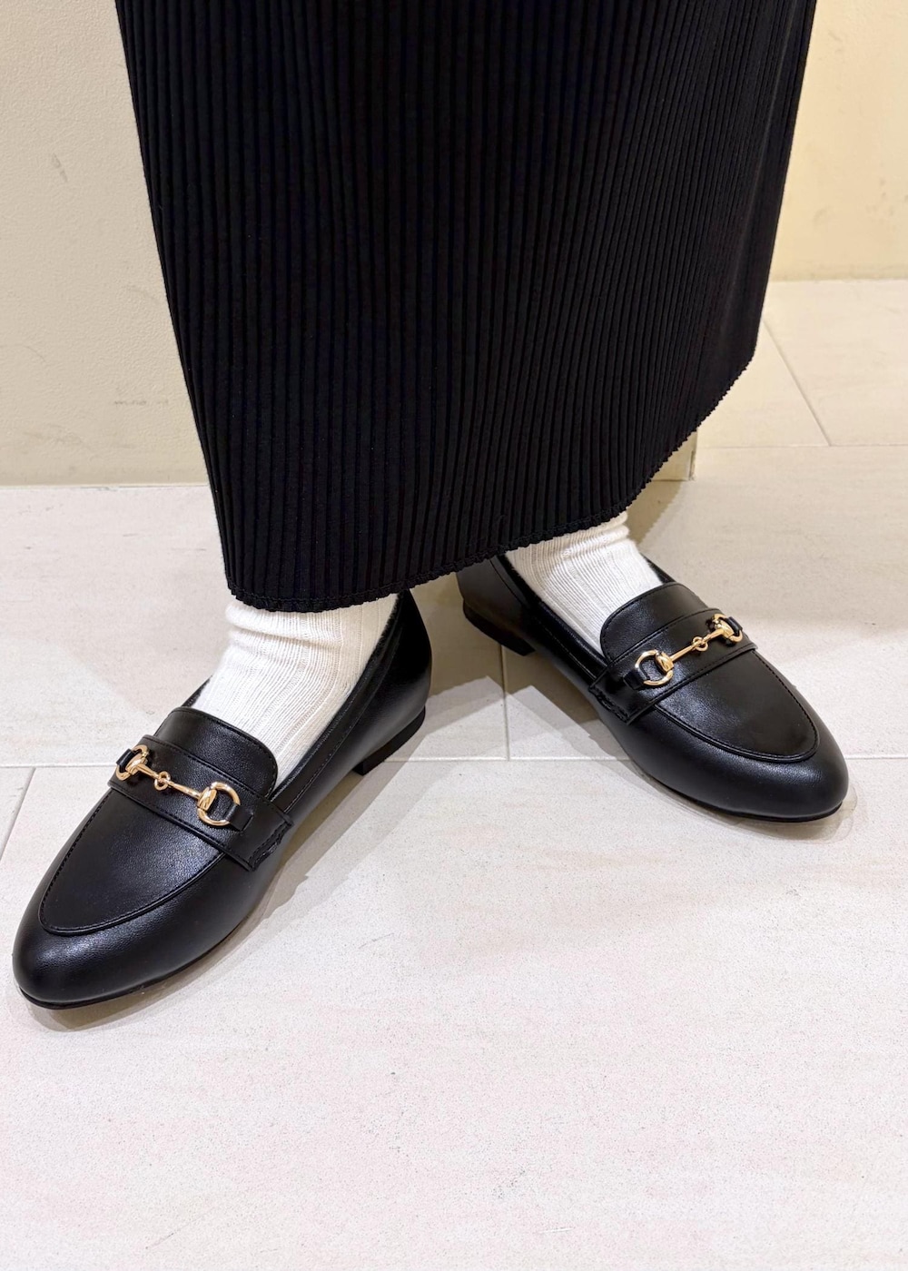 ホワイト系のニット/セーター、ブラック系のローファー、ホワイト系のボストンバッグを着用したレディースの冬コーディネートの10枚目の写真