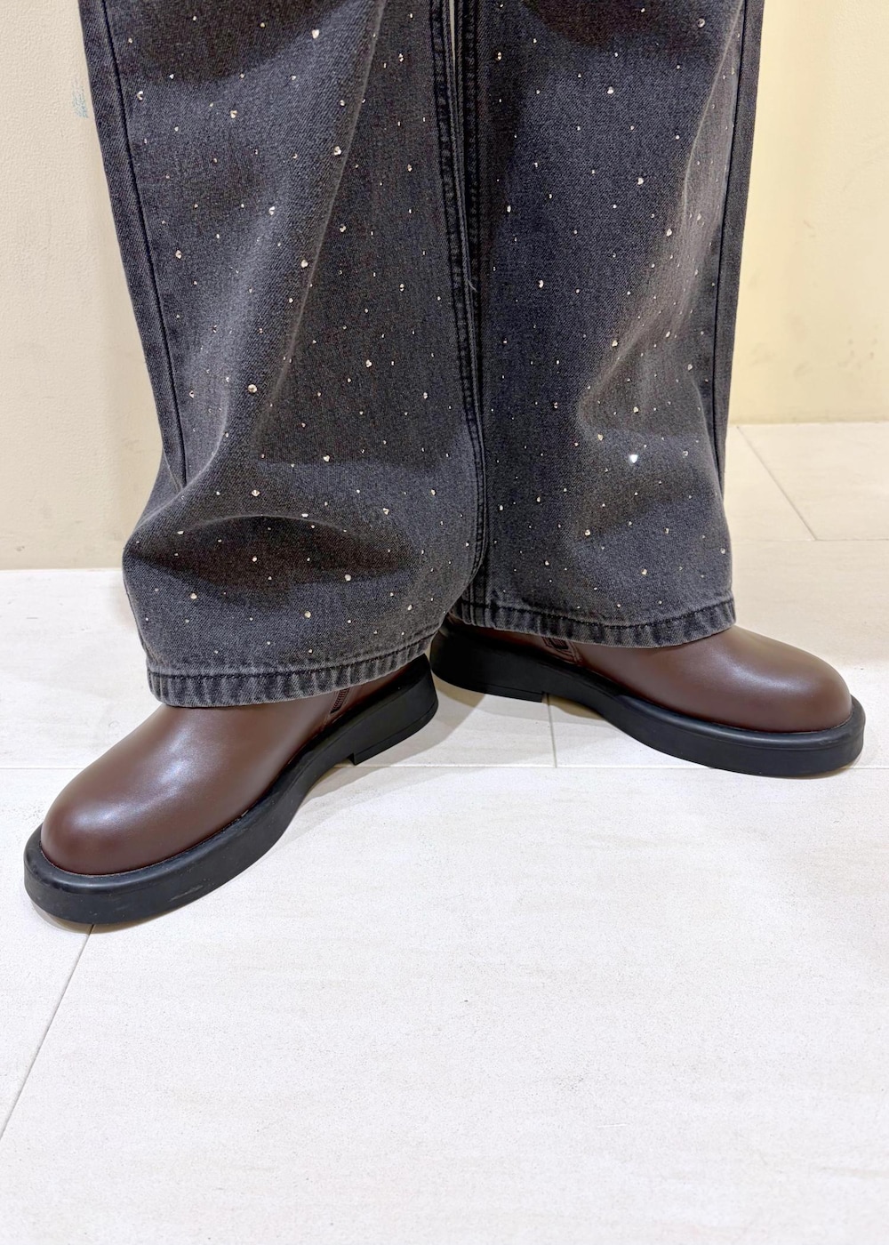 ブラック系のデニムパンツ、ブラウン系のブーツ、グレー系のニット/セーターを着用したレディースの冬コーディネートの10枚目の写真