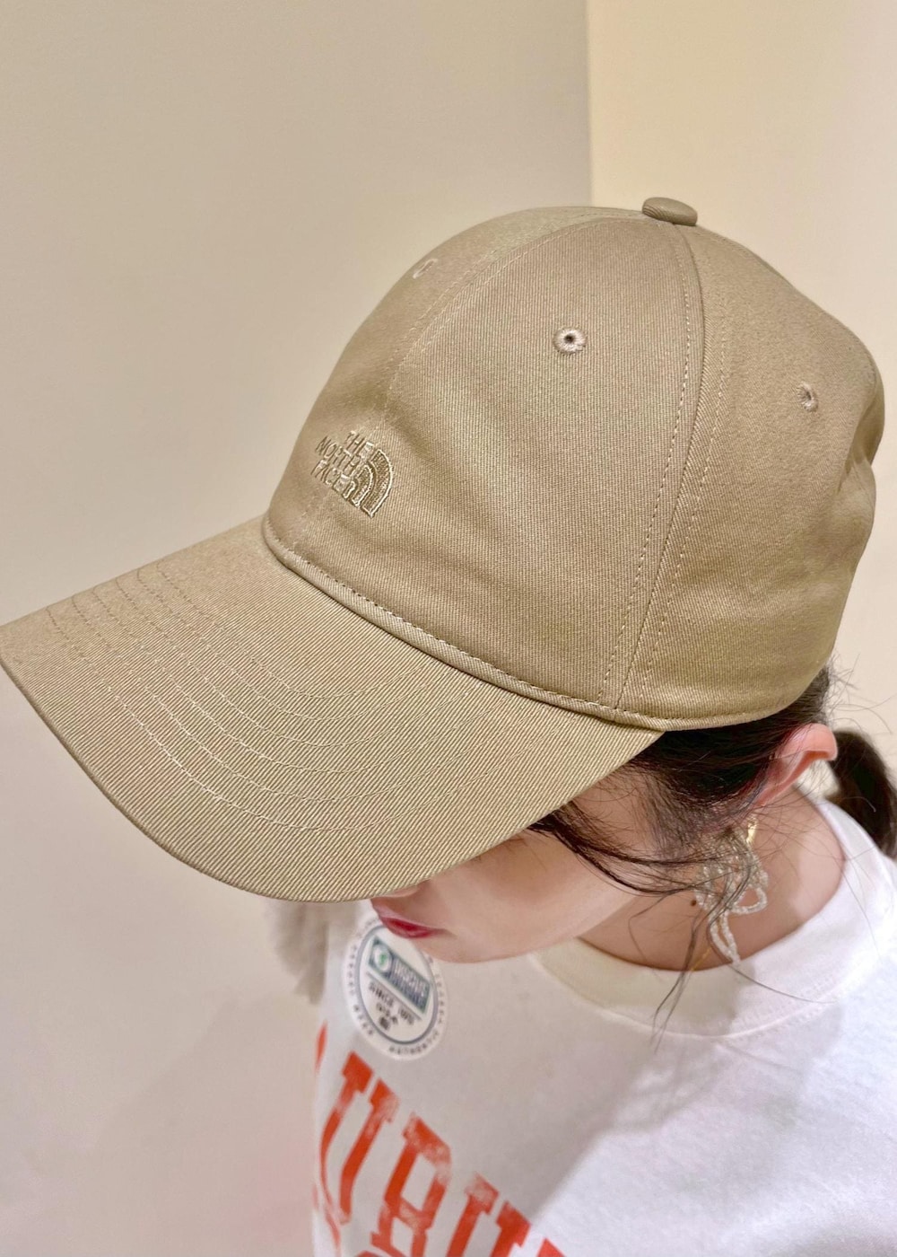 オレンジ系のスカート、ベージュ系のショルダーバッグ、ホワイト系のTシャツ/カットソーを着用したレディースの夏コーディネートの5枚目の写真