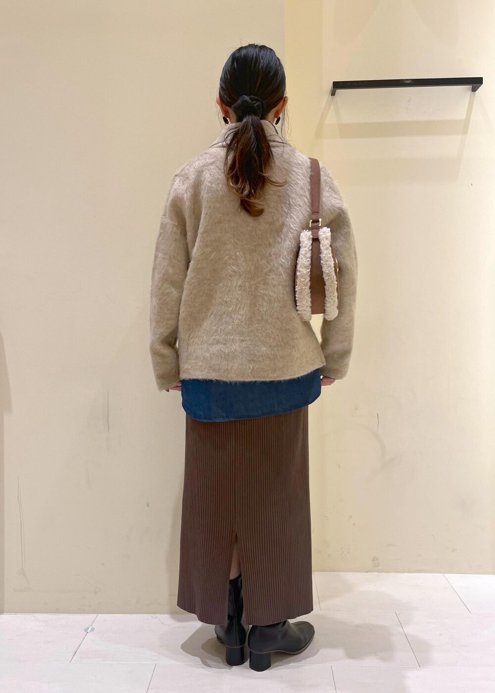 ブルー系のシャツ/ブラウス、ベージュ系のカーディガン/ボレロ、ブラック系のブーツを着用したレディースの秋コーディネートの3枚目の写真