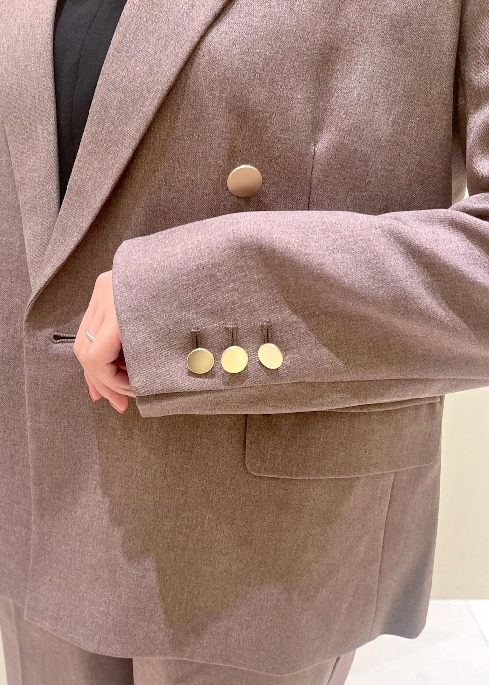 ブラック系のショルダーバッグ、ブラック系のシャツ/ブラウス、ベージュ系のテーラードジャケットを着用したレディースの秋コーディネートの6枚目の写真