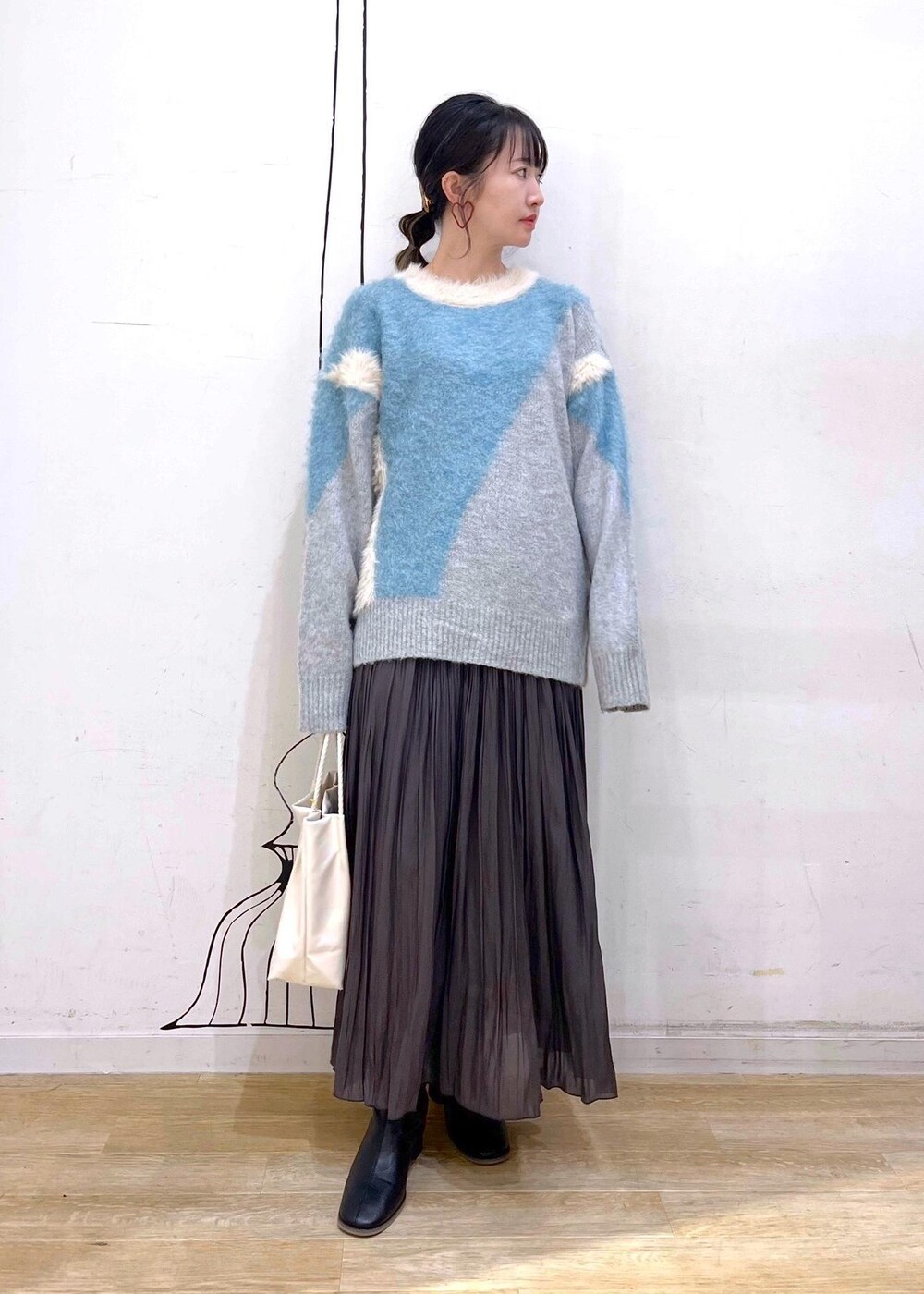 ブラック系のブーツ、ブルー系のニット/セーター、ブラウン系のスカートを着用したレディースの秋コーディネートの3枚目の写真