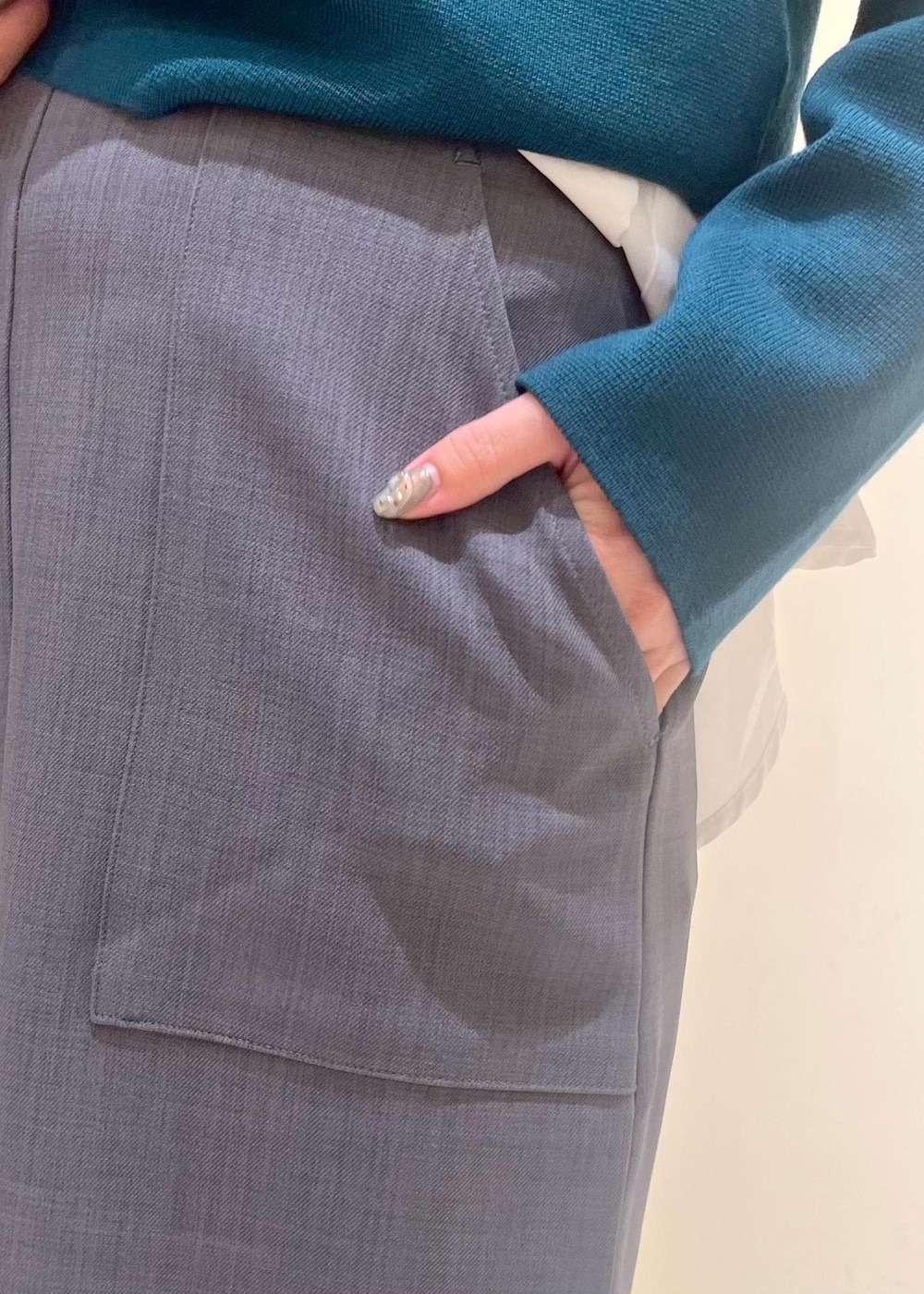 グレー系のスカート、ホワイト系のシャツ/ブラウス、グリーン系のカーディガン/ボレロを着用したレディースの秋コーディネートの9枚目の写真