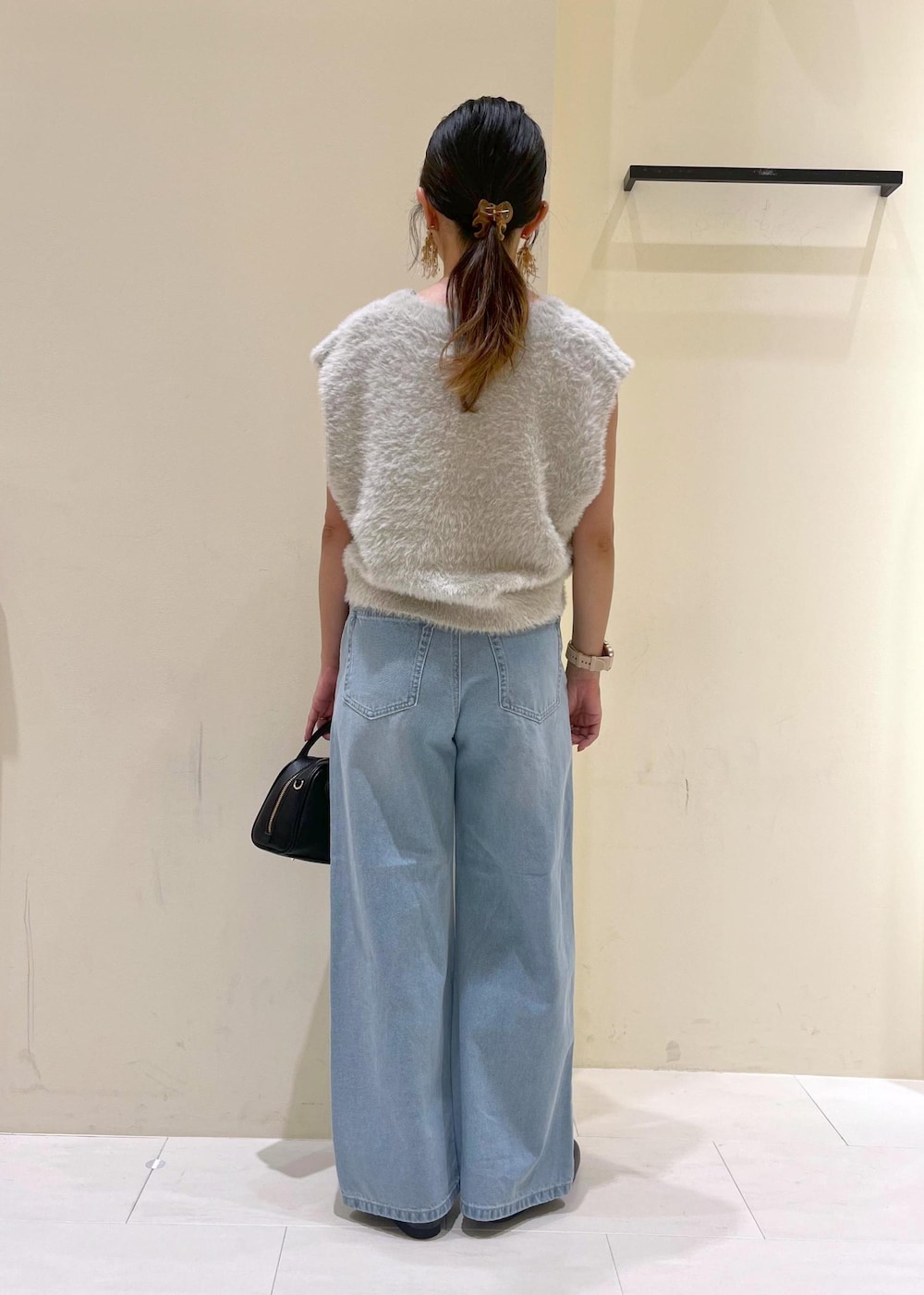 ブルー系のデニムパンツ、グレー系のベスト、ブラック系のローファーを着用したレディースの秋コーディネートの3枚目の写真