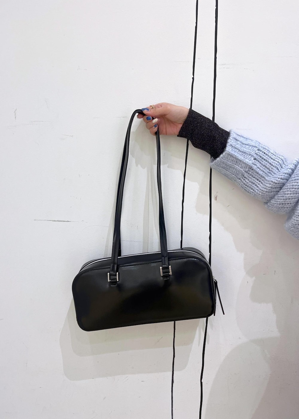 ブラック系のニット/セーター、ブラック系のブーツ、ブラック系のボストンバッグを着用したレディースの冬コーディネートの9枚目の写真