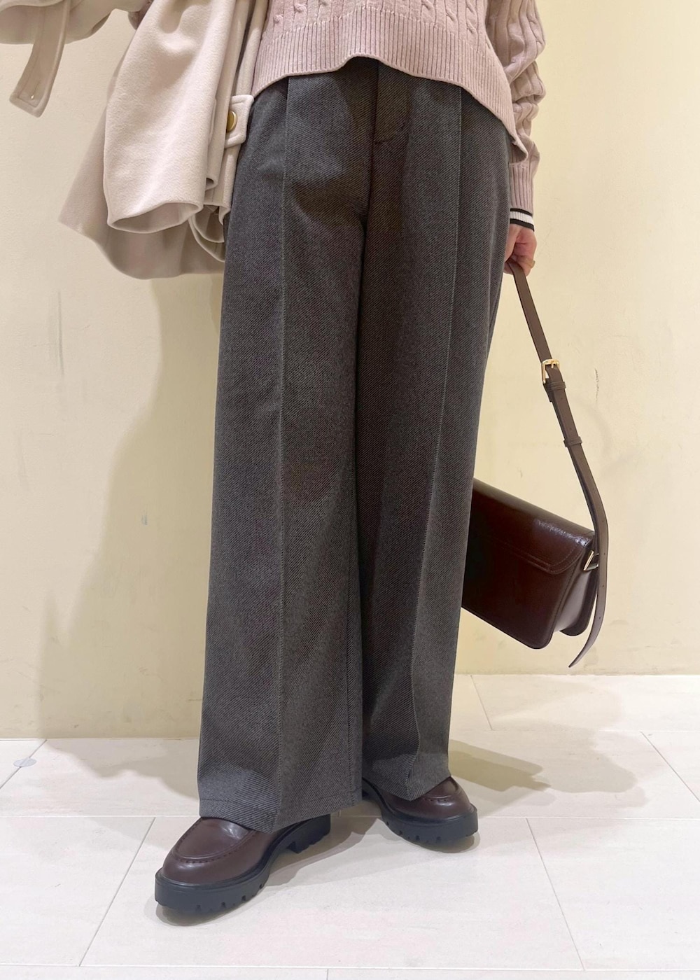 レッド系のショルダーバッグ、ホワイト系のニット/セーター、ベージュ系のその他アウターを着用したレディースの冬コーディネートの8枚目の写真