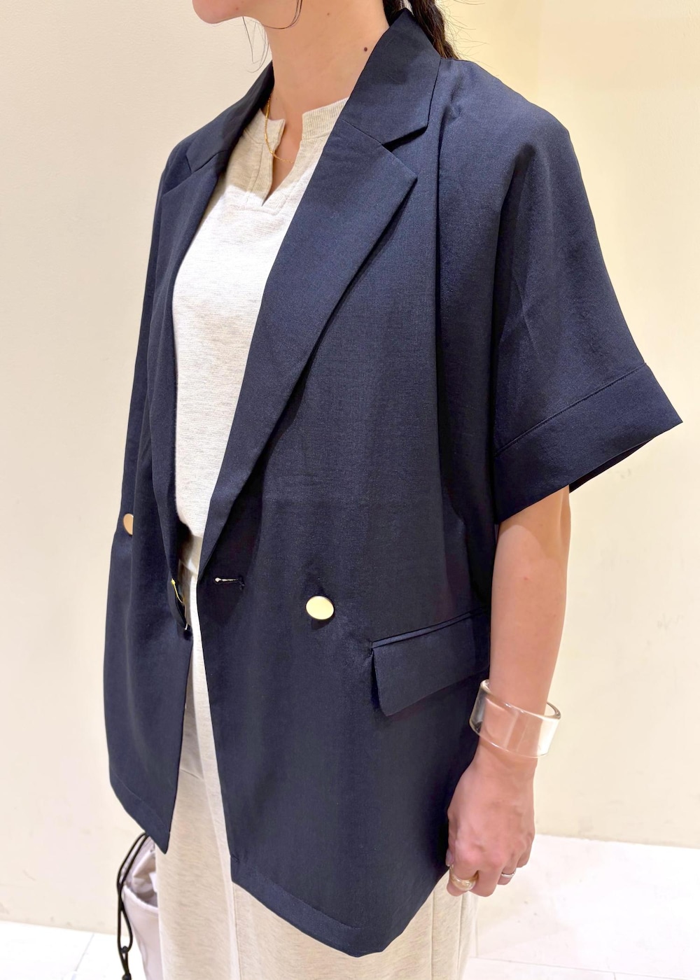 グレー系のスカート、グレー系のTシャツ/カットソー、ブルー系のテーラードジャケットを着用したレディースの秋コーディネートの5枚目の写真