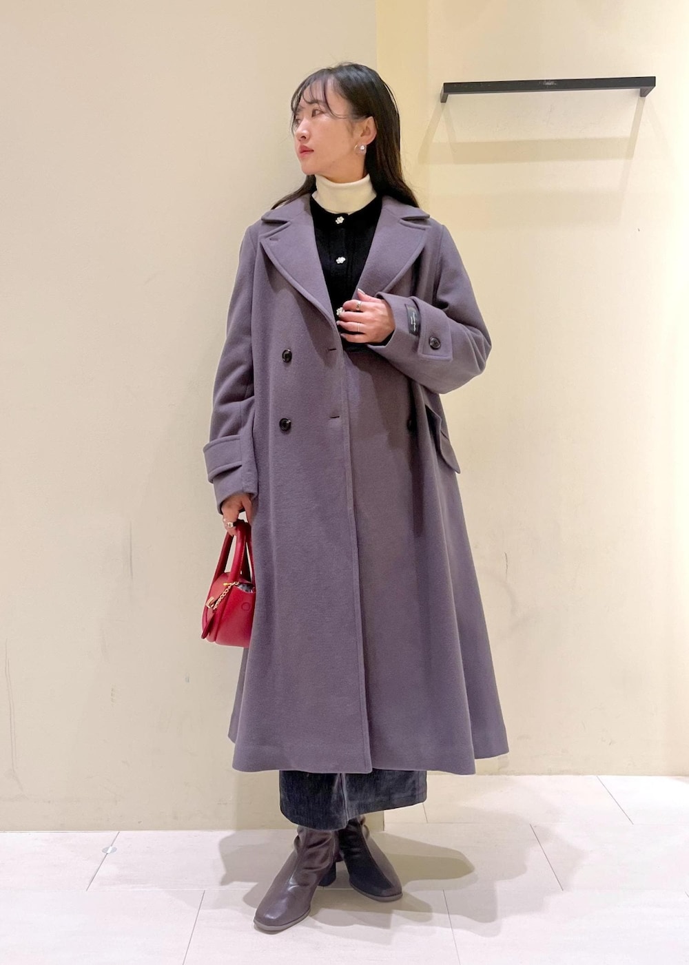 ホワイト系のニット/セーター、グレー系のチェスターコート、レッド系のショルダーバッグを着用したレディースの冬コーディネートの2枚目の写真