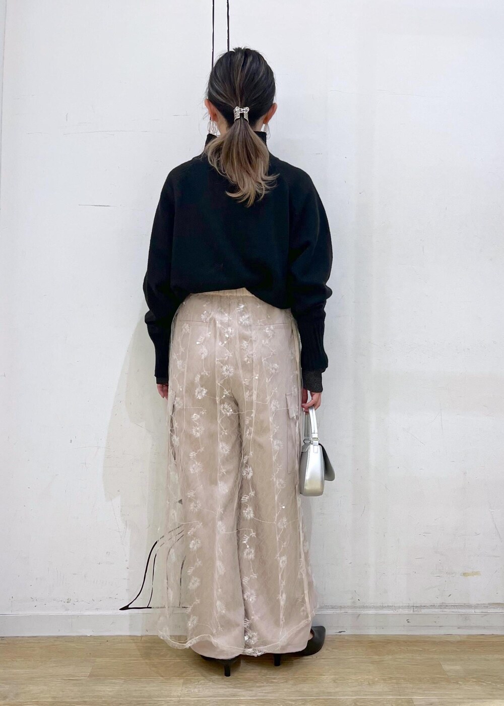 ブラック系のニット/セーター、ホワイト系のスカート、ブラック系のパンプスを着用したレディースの冬コーディネートの4枚目の写真