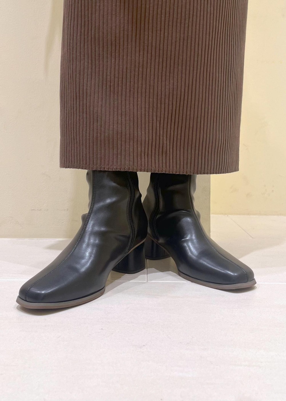 ベージュ系のシャツ/ブラウス、ブラック系のブーツ、グリーン系のスカートを着用したレディースの秋コーディネートの9枚目の写真