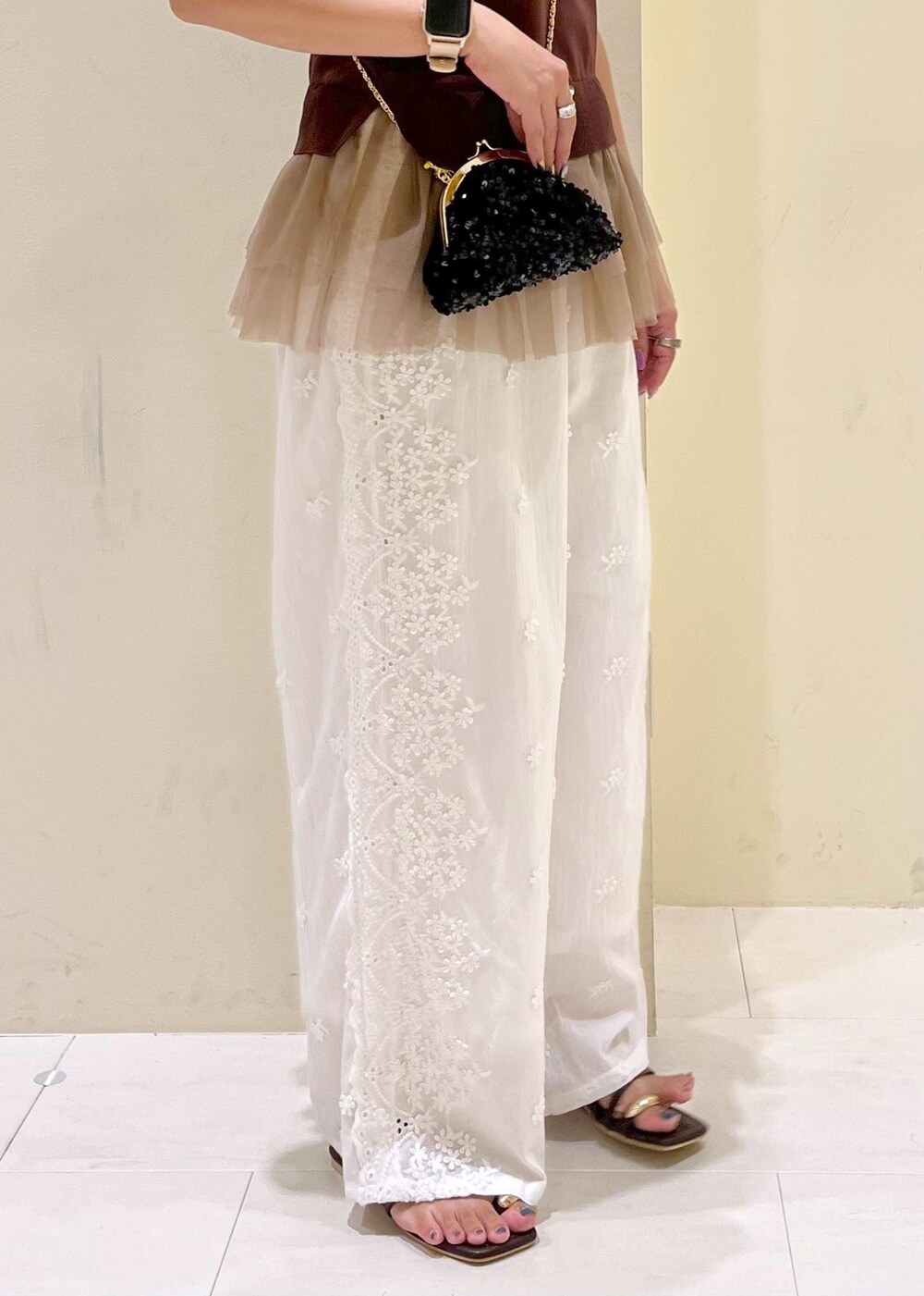 ブラック系のショルダーバッグ、ブラック系のサンダル、ホワイト系のその他パンツを着用したレディースの夏コーディネートの8枚目の写真