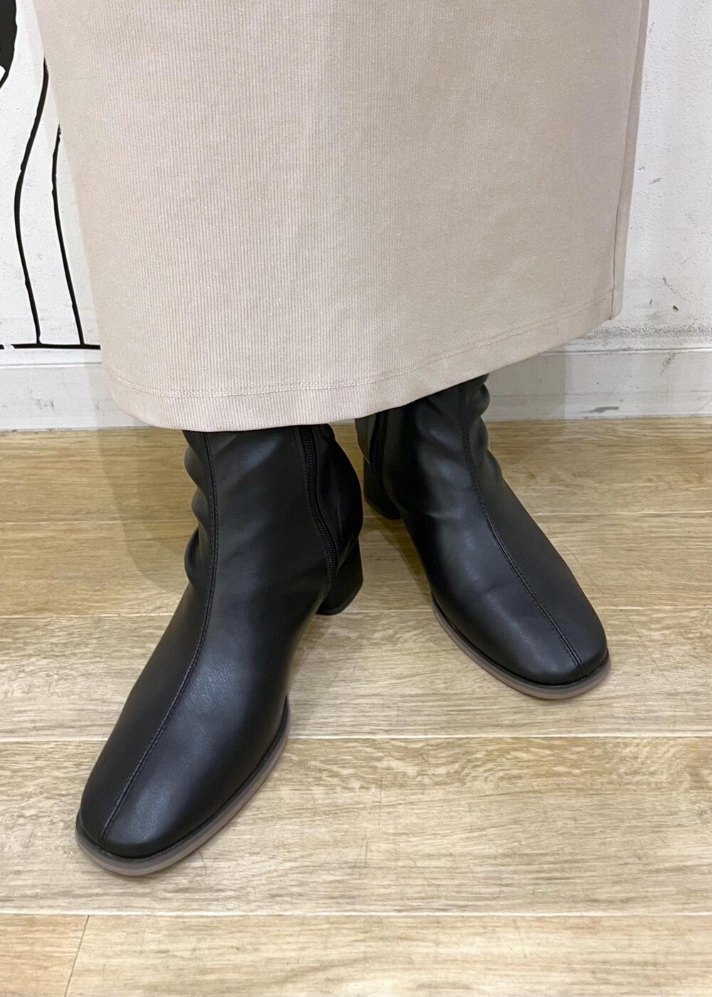 ベージュ系のスカート、レッド系のニット/セーター、ブラック系のブーツを着用したレディースの秋コーディネートの10枚目の写真