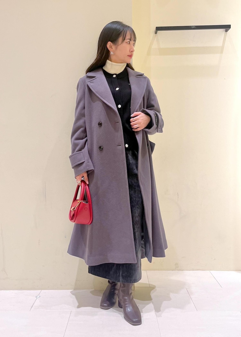 グレー系のスカート、ブラック系のカーディガン/ボレロ、ホワイト系のニット/セーターを着用したレディースの冬コーディネートの10枚目の写真