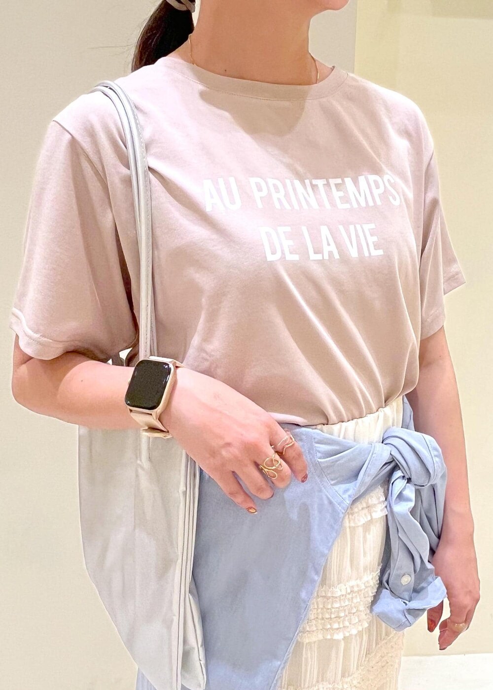 シルバー系のトートバッグ、ブラック系のローファー、ベージュ系のTシャツ/カットソーを着用したレディースの春コーディネートの5枚目の写真