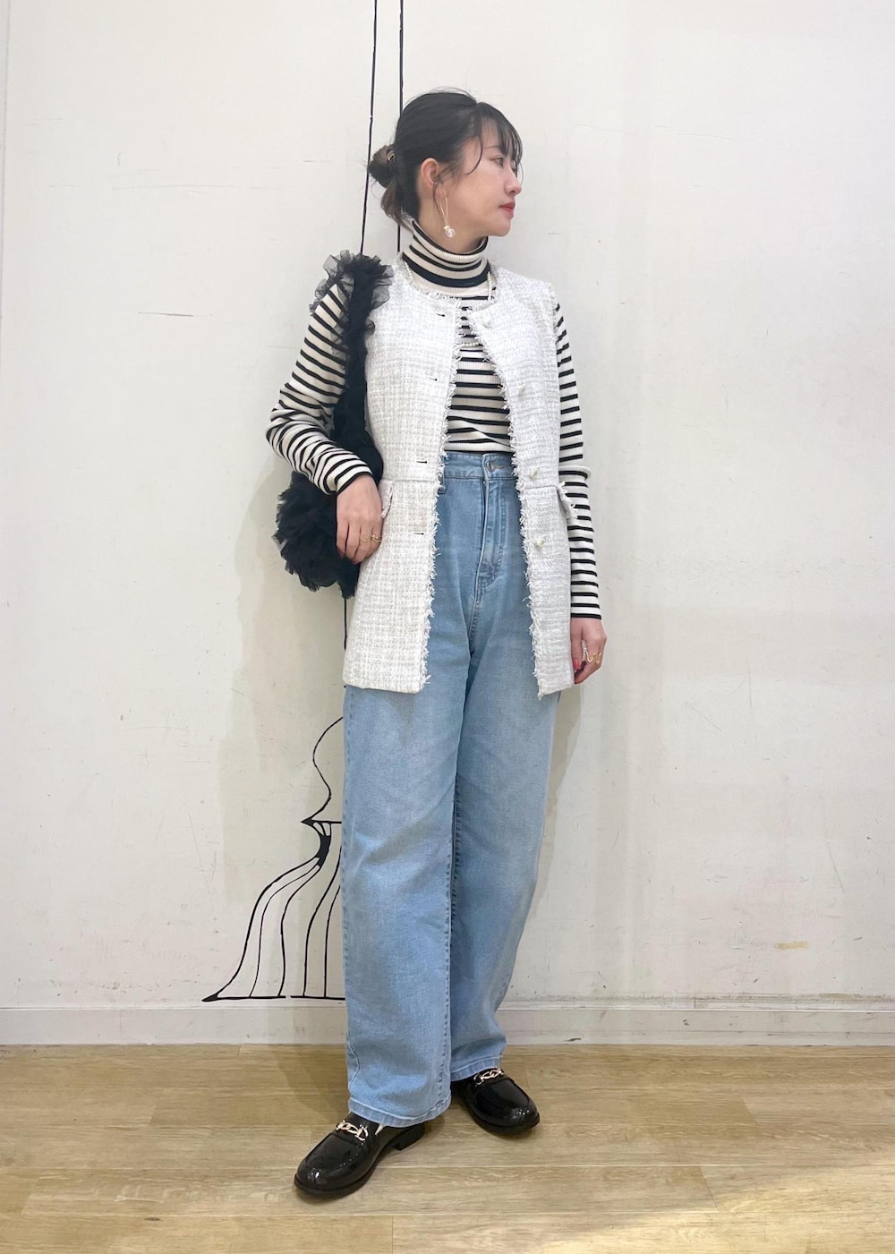 ホワイト系のニット/セーター、ブルー系のデニムパンツ、ブラック系のレインシューズを着用したレディースの冬コーディネートの3枚目の写真