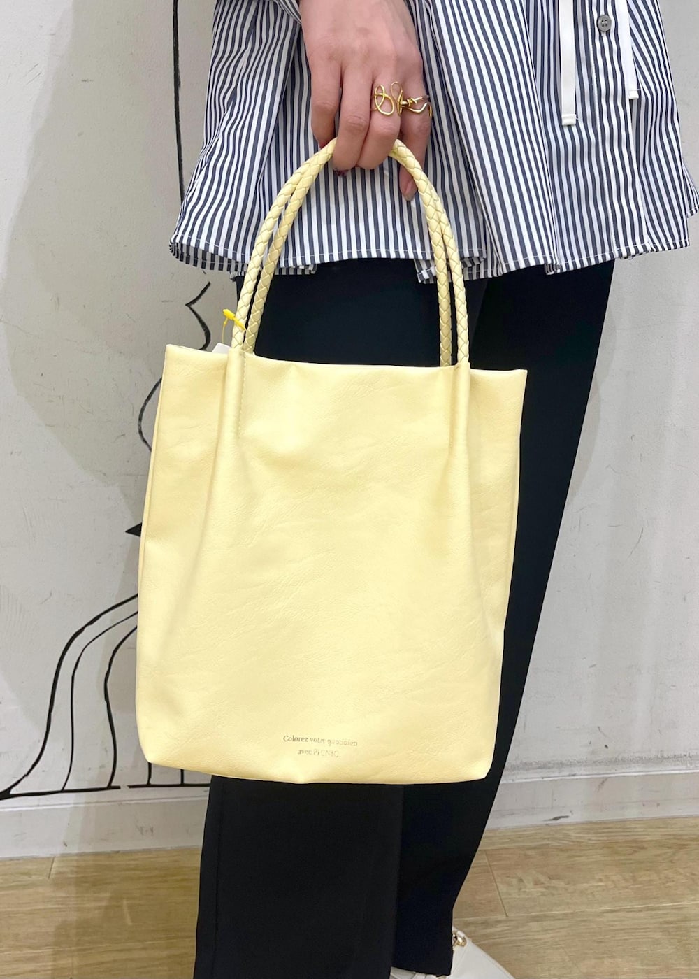 ホワイト系のベスト、ブルー系のその他パンツ、イエロー系のトートバッグを着用したレディースの冬コーディネートの9枚目の写真