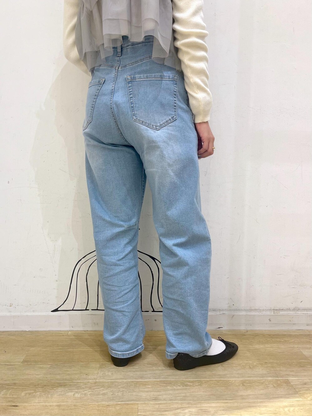 ブルー系のデニムパンツ、レッド系のトートバッグ、ブラック系のその他アウターを着用したレディースの冬コーディネートの8枚目の写真