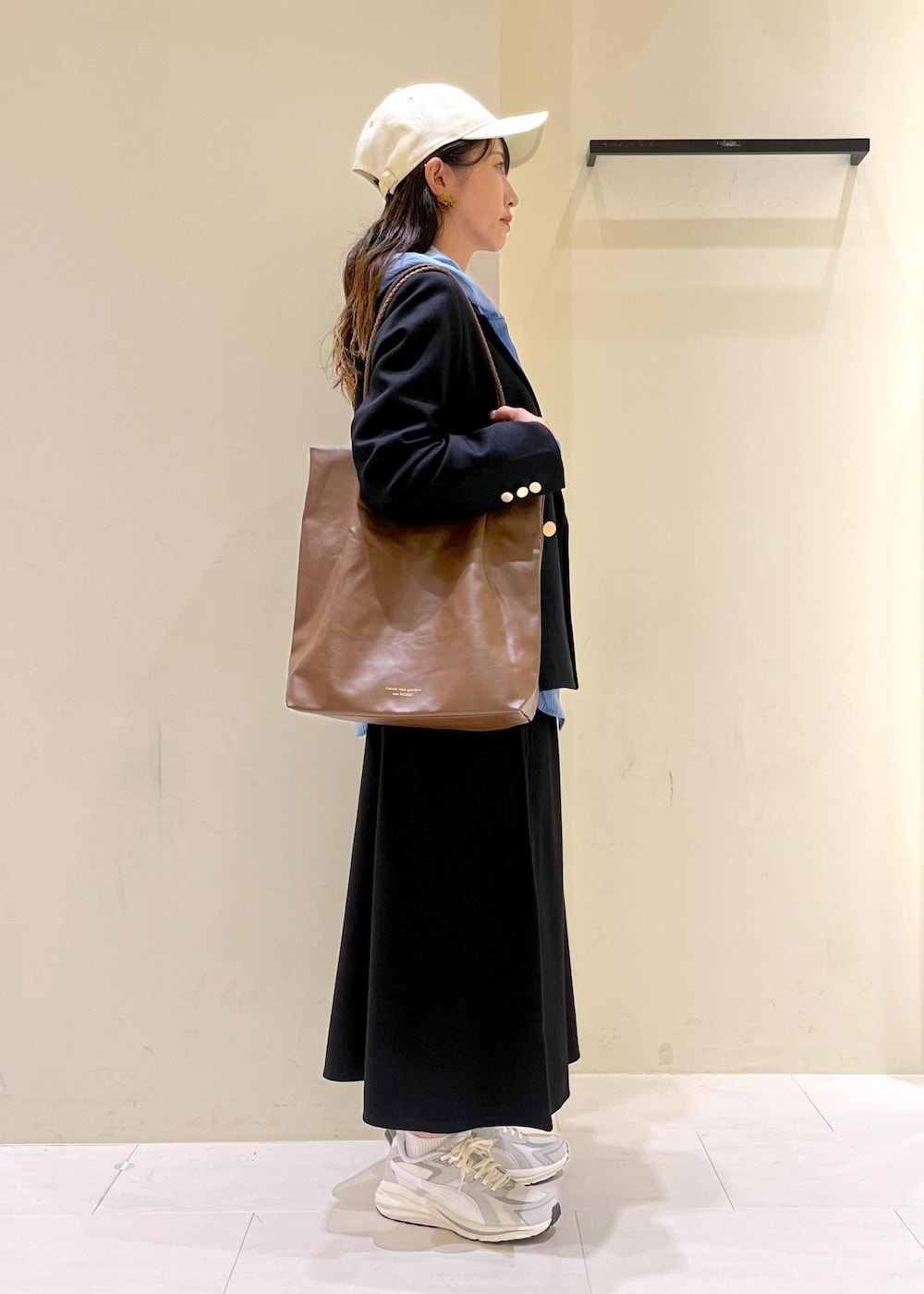 ブラウン系のトートバッグ、ブラウン系のトートバッグ、ブルー系のテーラードジャケットを着用したレディースの秋コーディネートの2枚目の写真