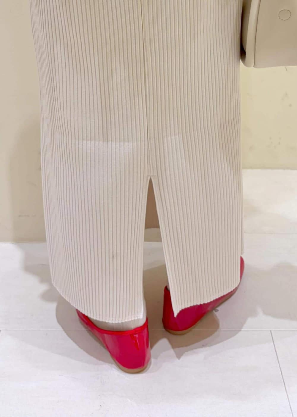 レッド系のバレエシューズ、ホワイト系のショルダーバッグ、ホワイト系のキャミソールを着用したレディースの冬コーディネートの8枚目の写真