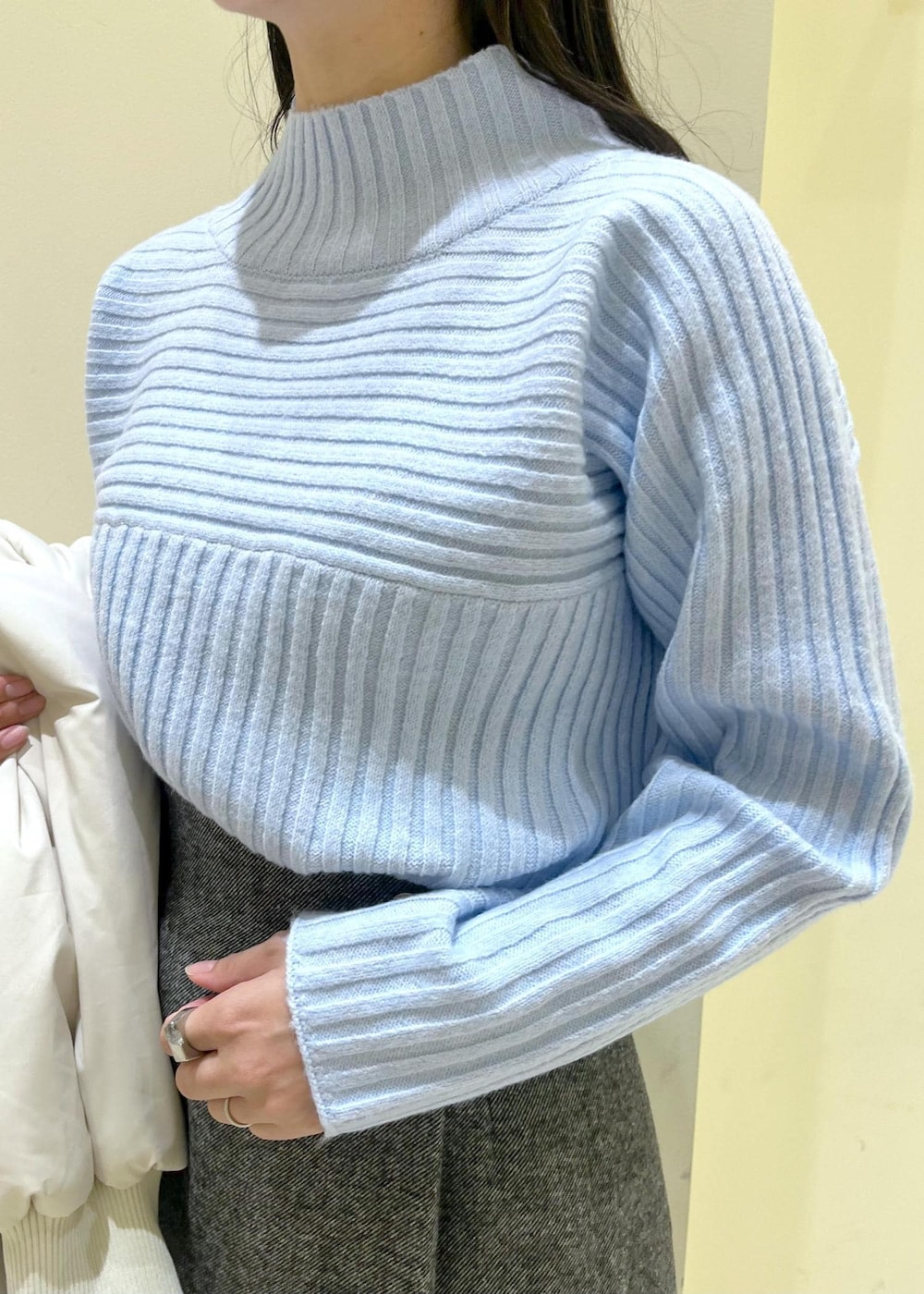 ブラック系のブーツ、ブラウン系のショルダーバッグ、ブルー系のニット/セーターを着用したレディースの冬コーディネートの5枚目の写真