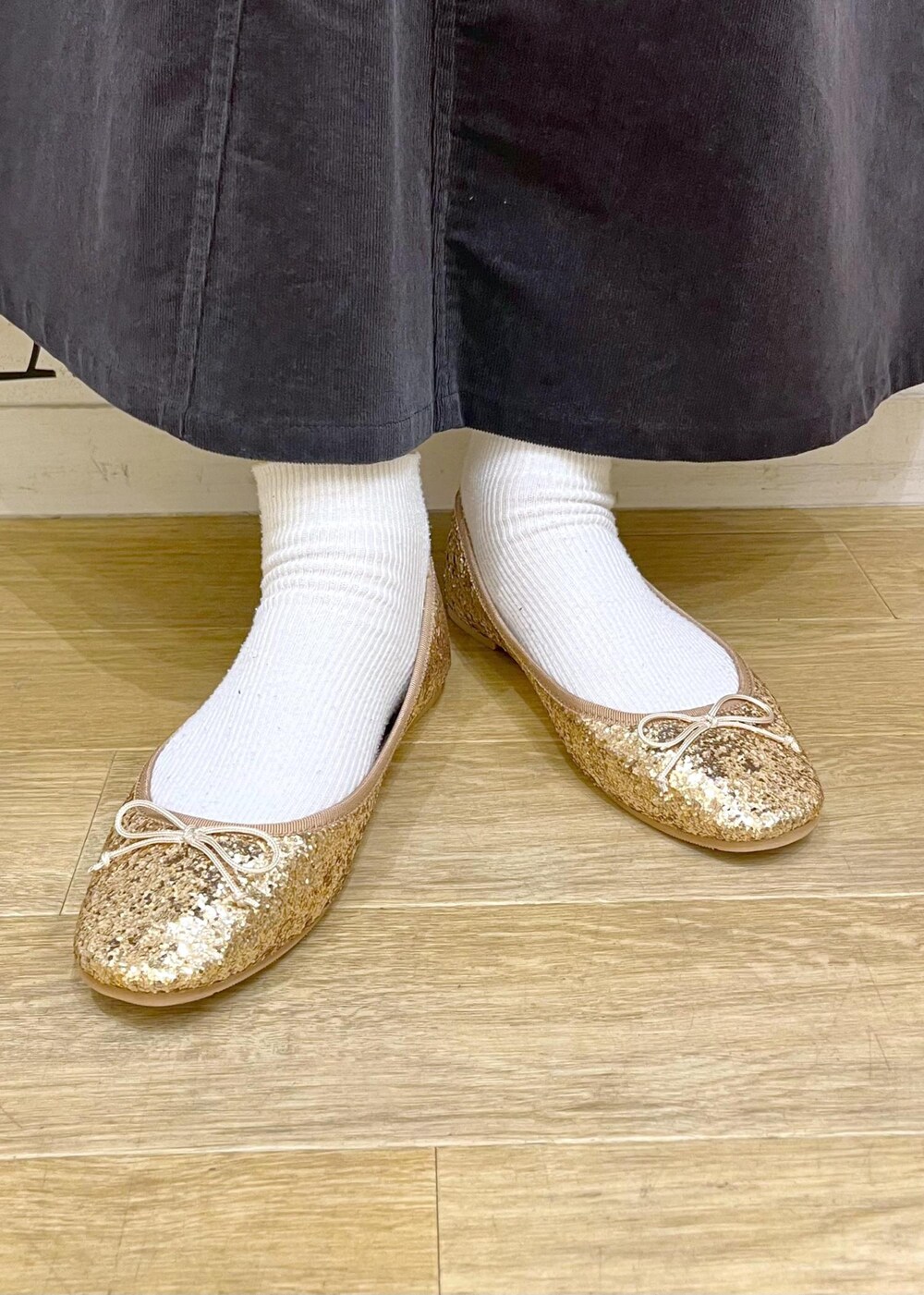 イエロー系のトートバッグ、グレー系のスカート、ブルー系のシャツ/ブラウスを着用したレディースの冬コーディネートの9枚目の写真