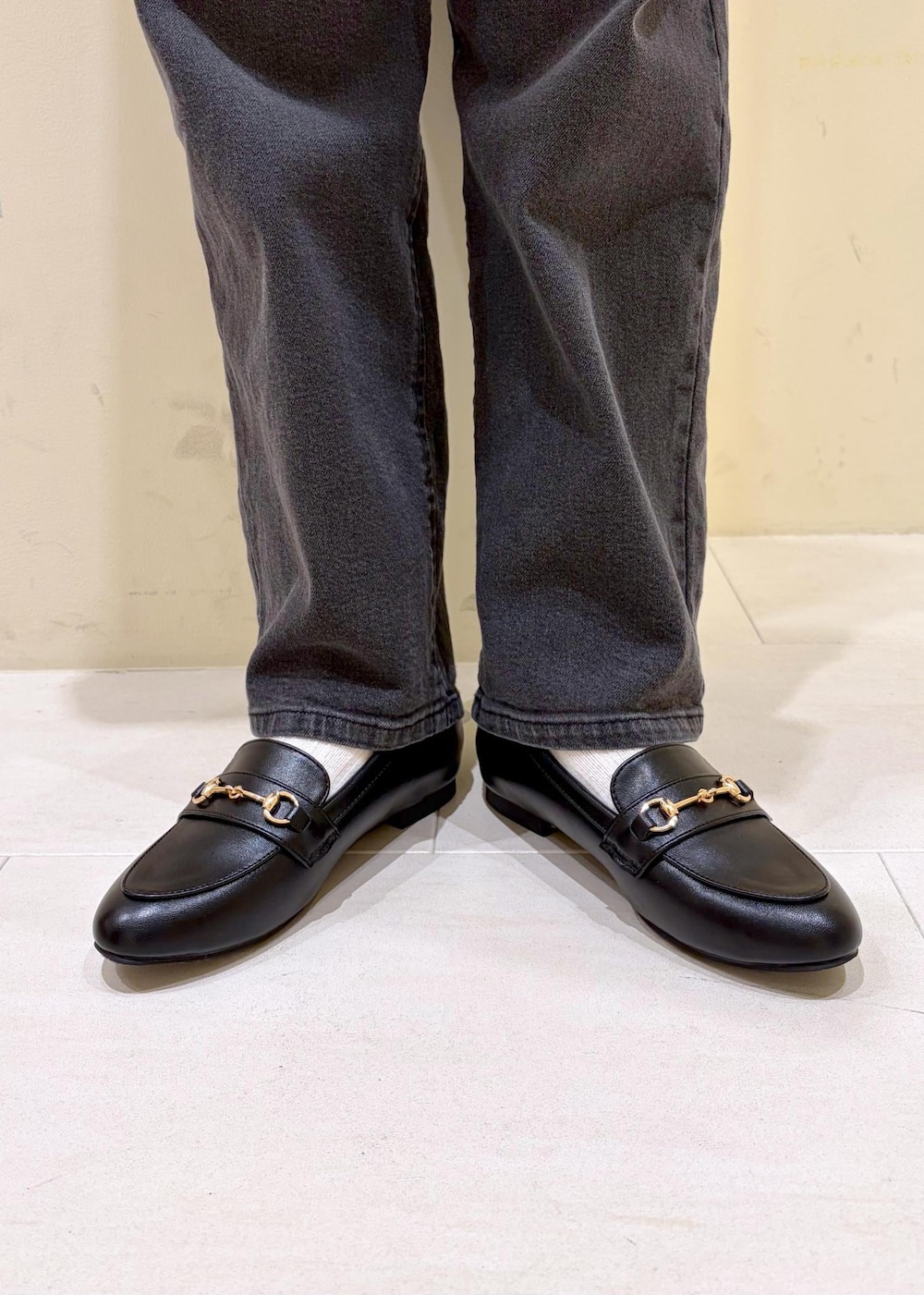 ブラック系のショルダーバッグ、ブラック系のローファー、グレー系のニット/セーターを着用したレディースの冬コーディネートの10枚目の写真