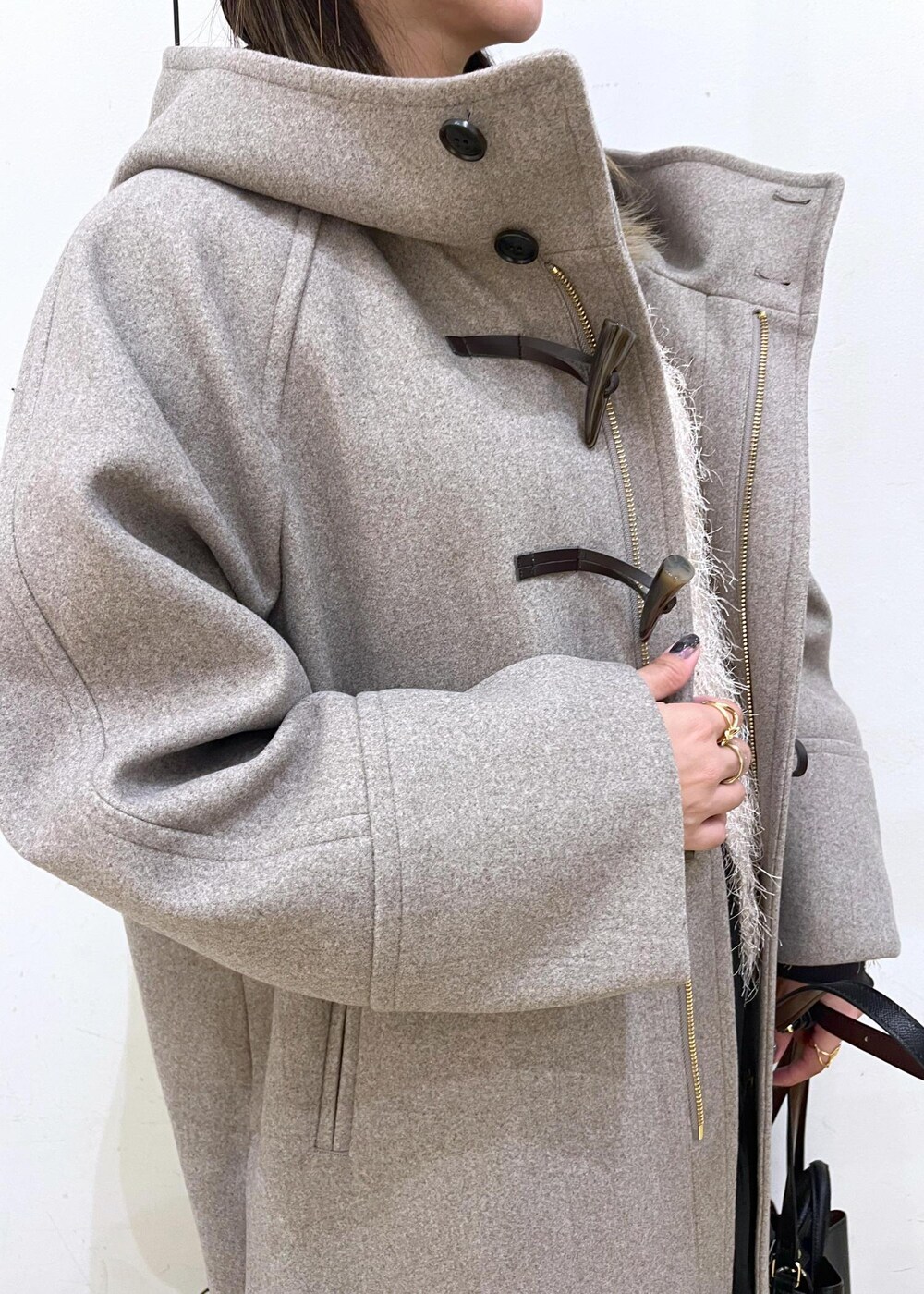 グレー系のTシャツ/カットソー、ベージュ系のカーディガン/ボレロ、ブラック系のブーツを着用したレディースの秋コーディネートの5枚目の写真