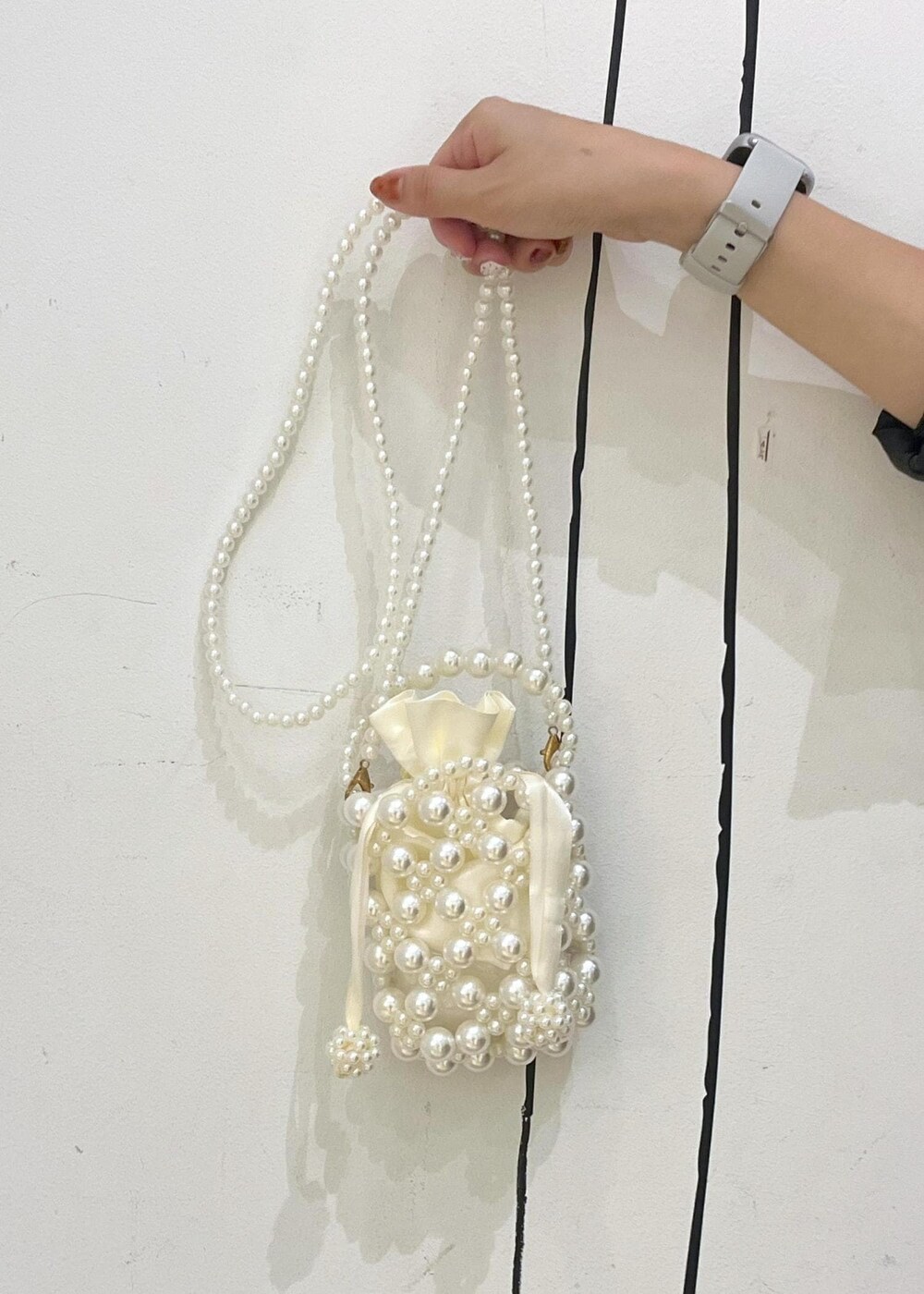 ホワイト系のスカート、ブラック系のニット/セーター、ブラック系のテーラードジャケットを着用したレディースの秋コーディネートの9枚目の写真