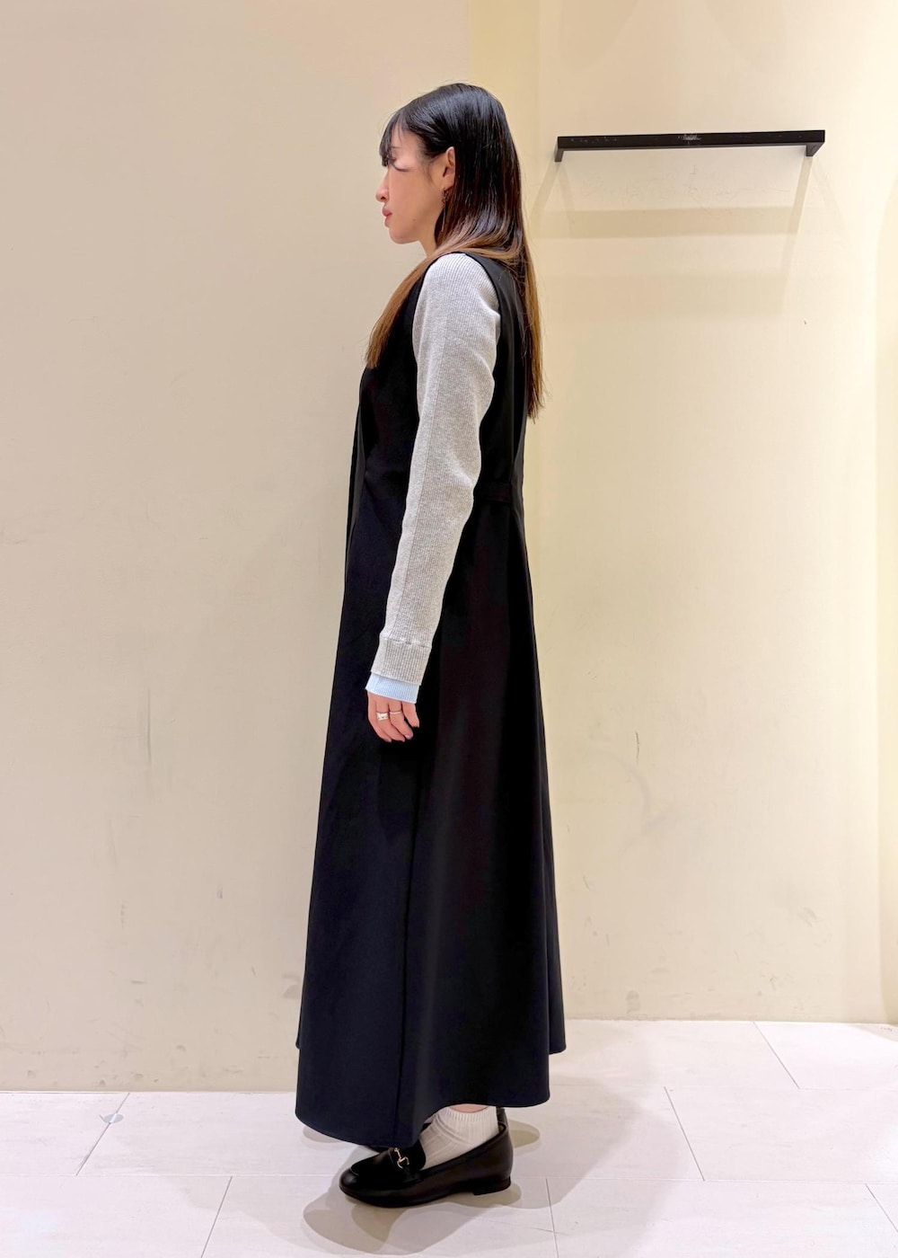 ブラック系のショルダーバッグ、ブラック系のローファー、グレー系のニット/セーターを着用したレディースの冬コーディネートの4枚目の写真